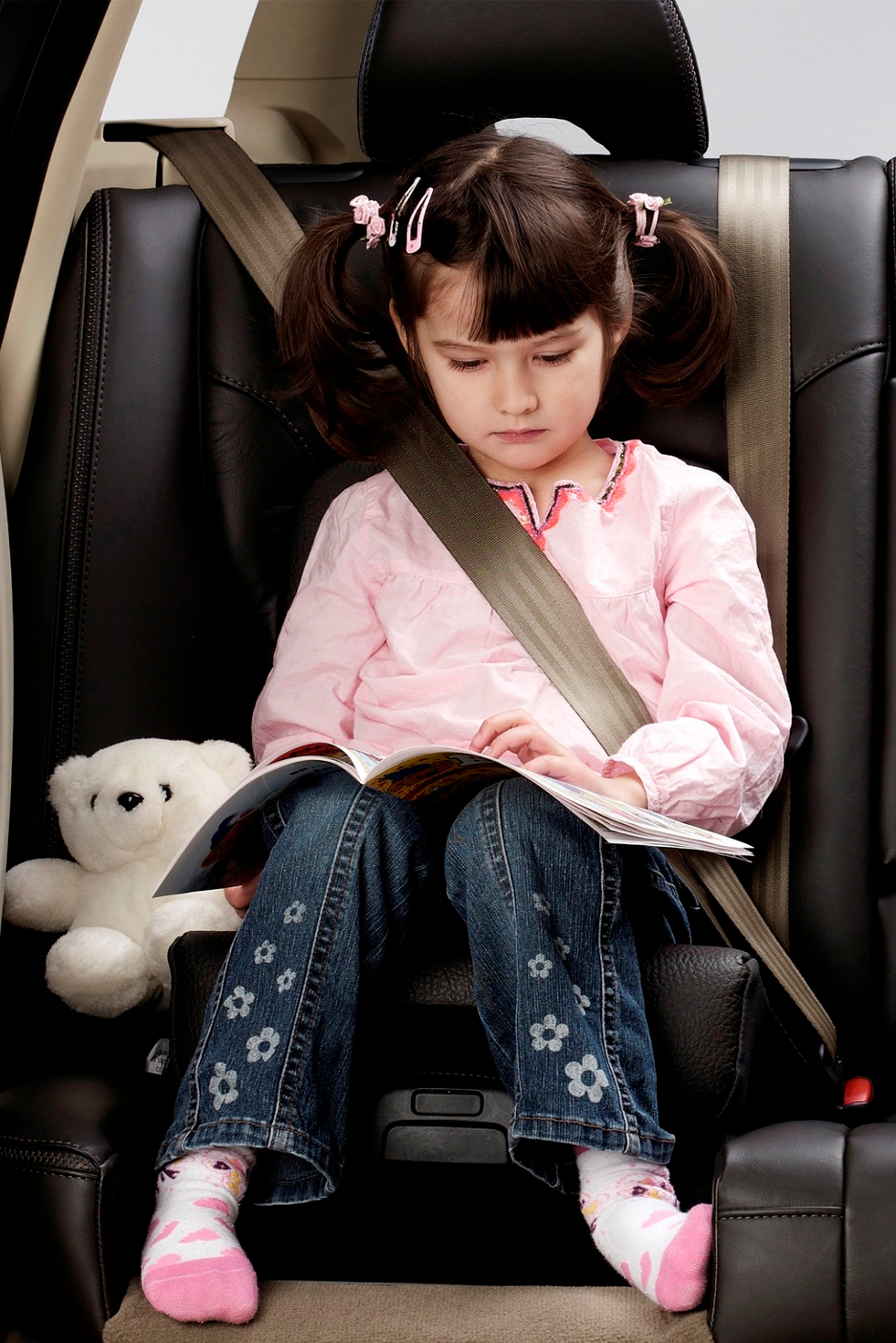 2 名儿童坐在沃尔沃后座对视。