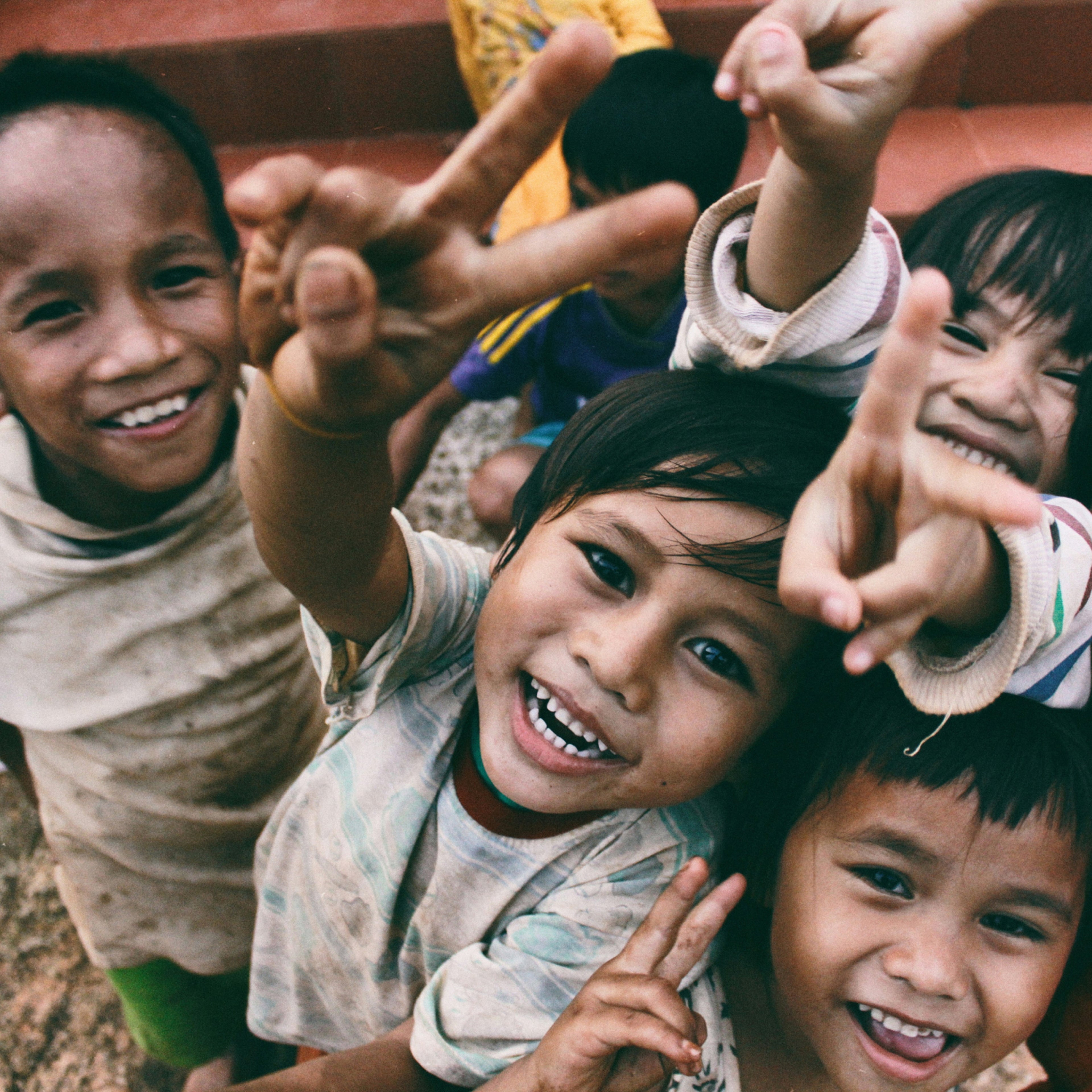 一群快乐的孩子微笑着做出和平的手势。