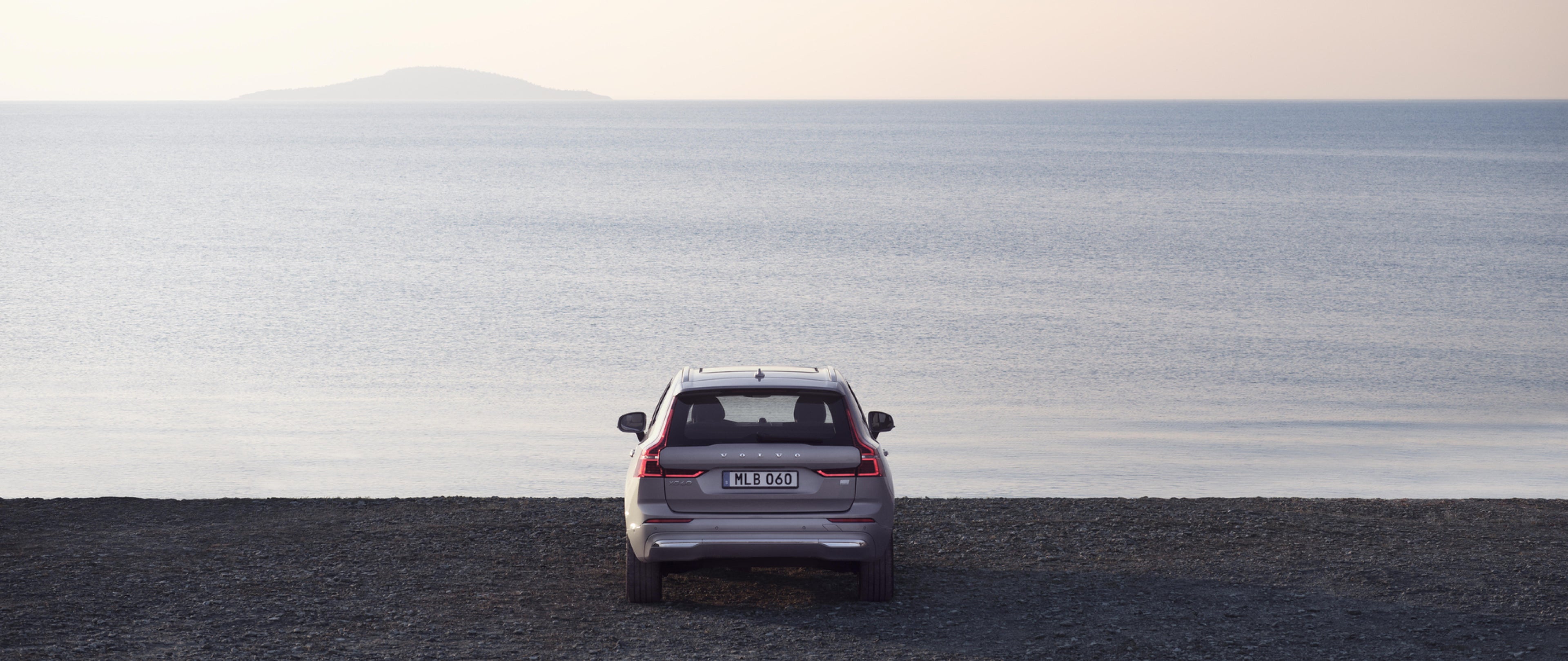 一名女士坐在黑色沙发上使用笔记本电脑。