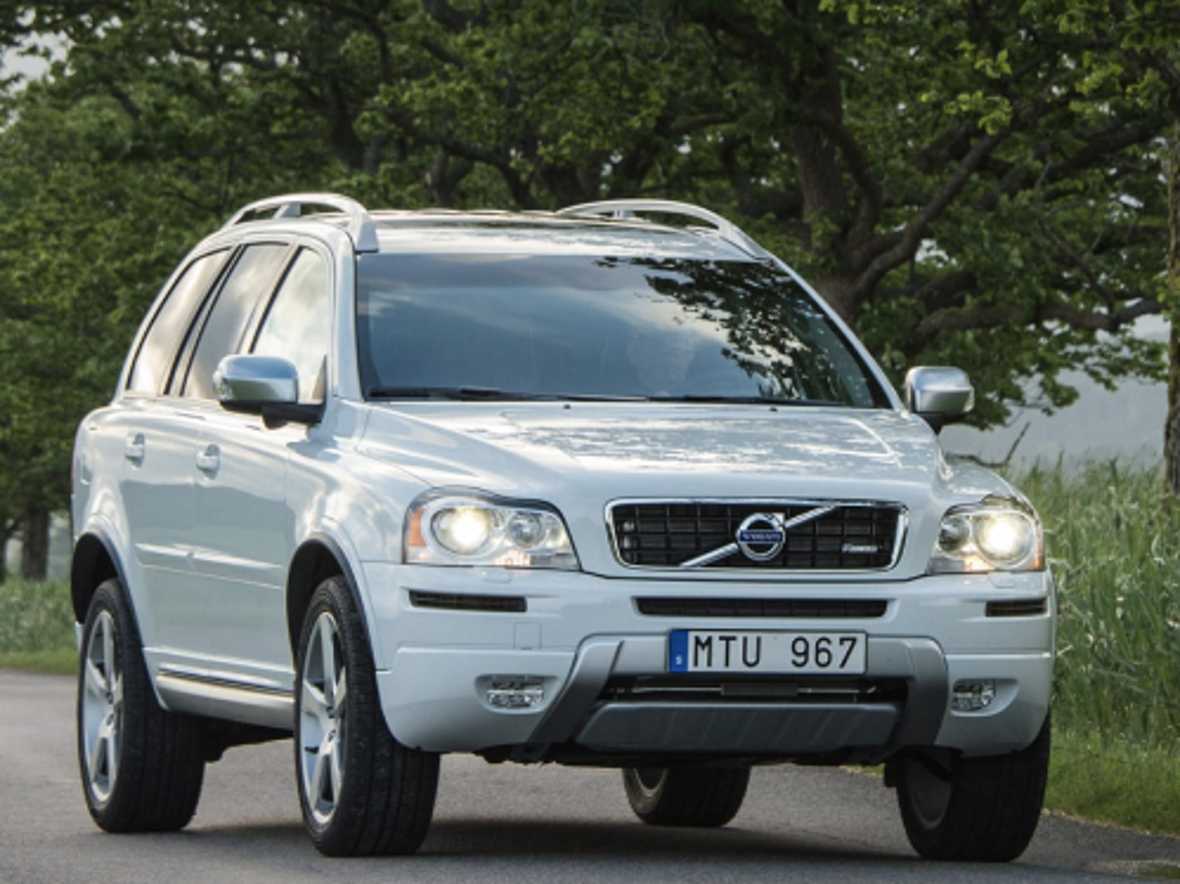 灰色沃尔沃 XC90 行驶在乡间小路上。