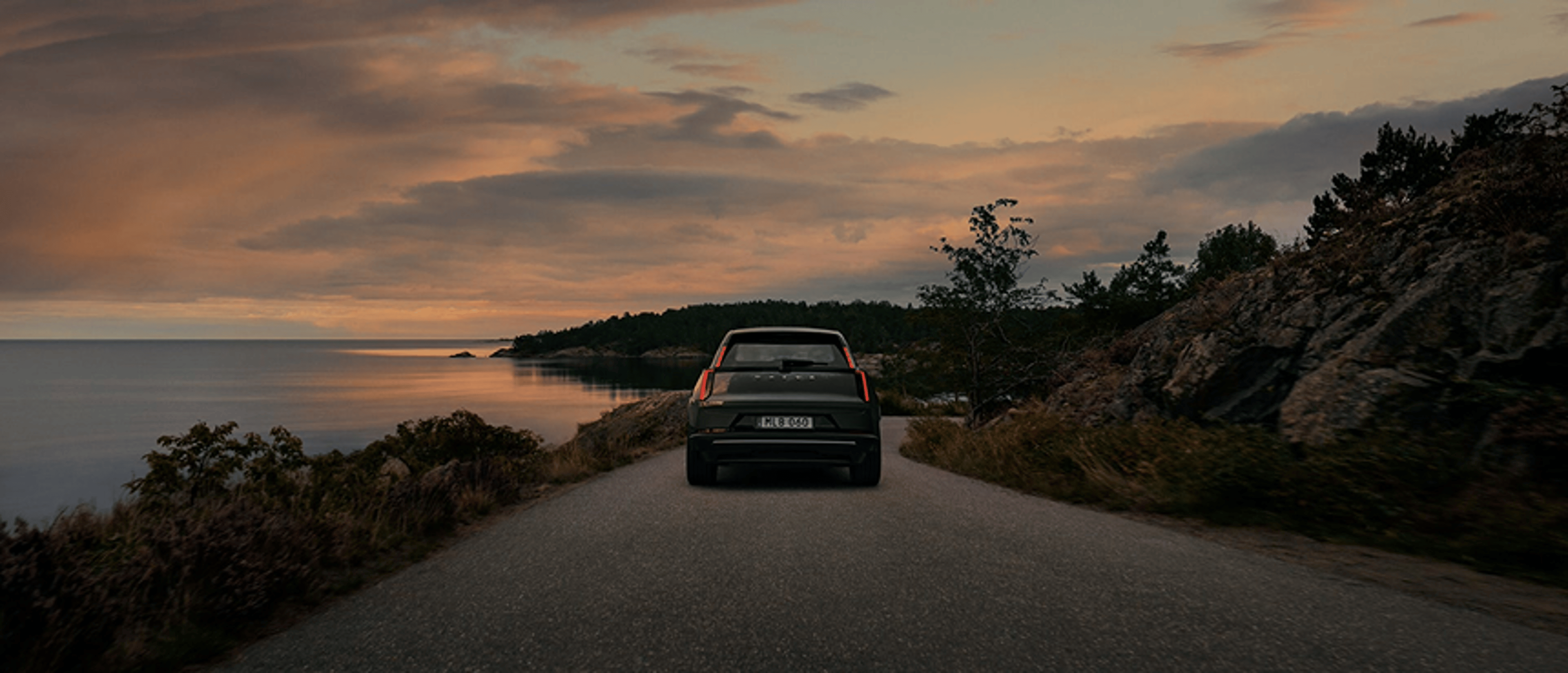 白色 VOLVO XC40 行驶在结冰路面的后视图。