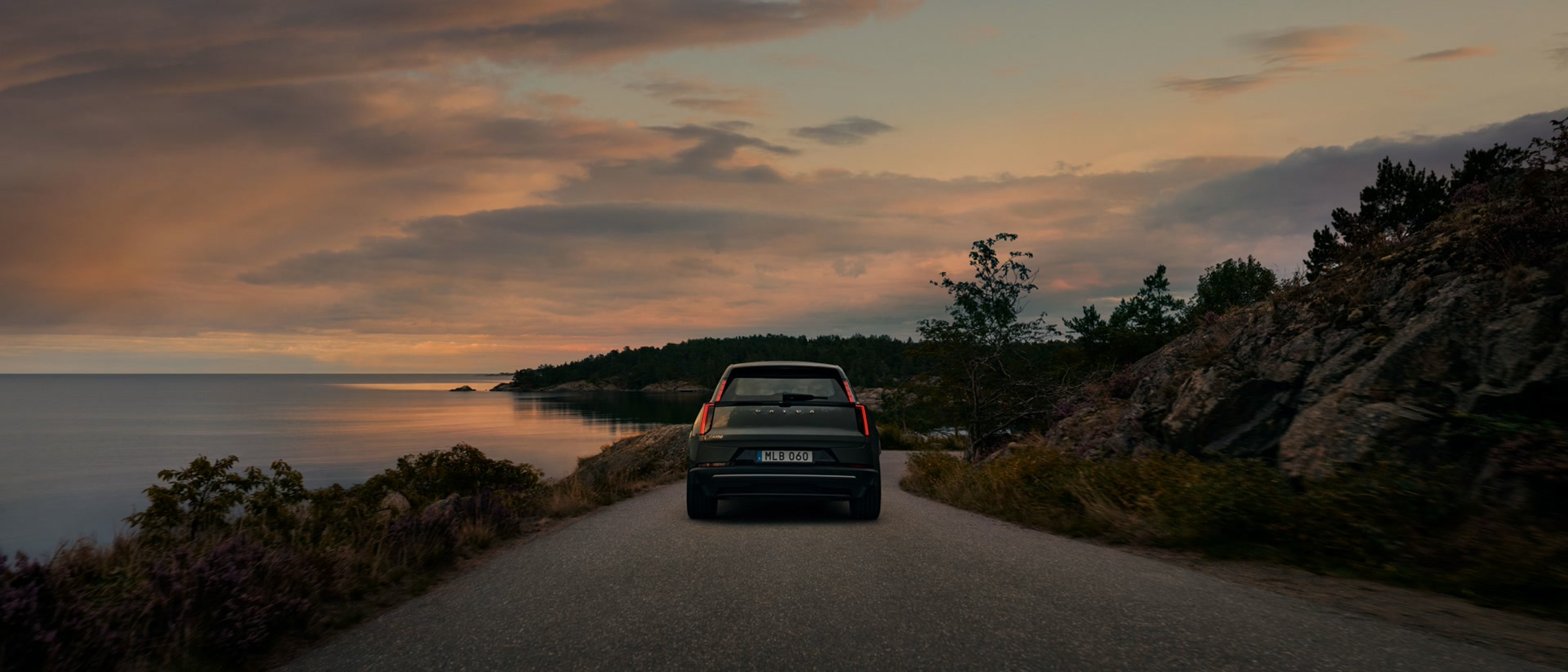 白色 VOLVO XC40 行驶在结冰路面的后视图。