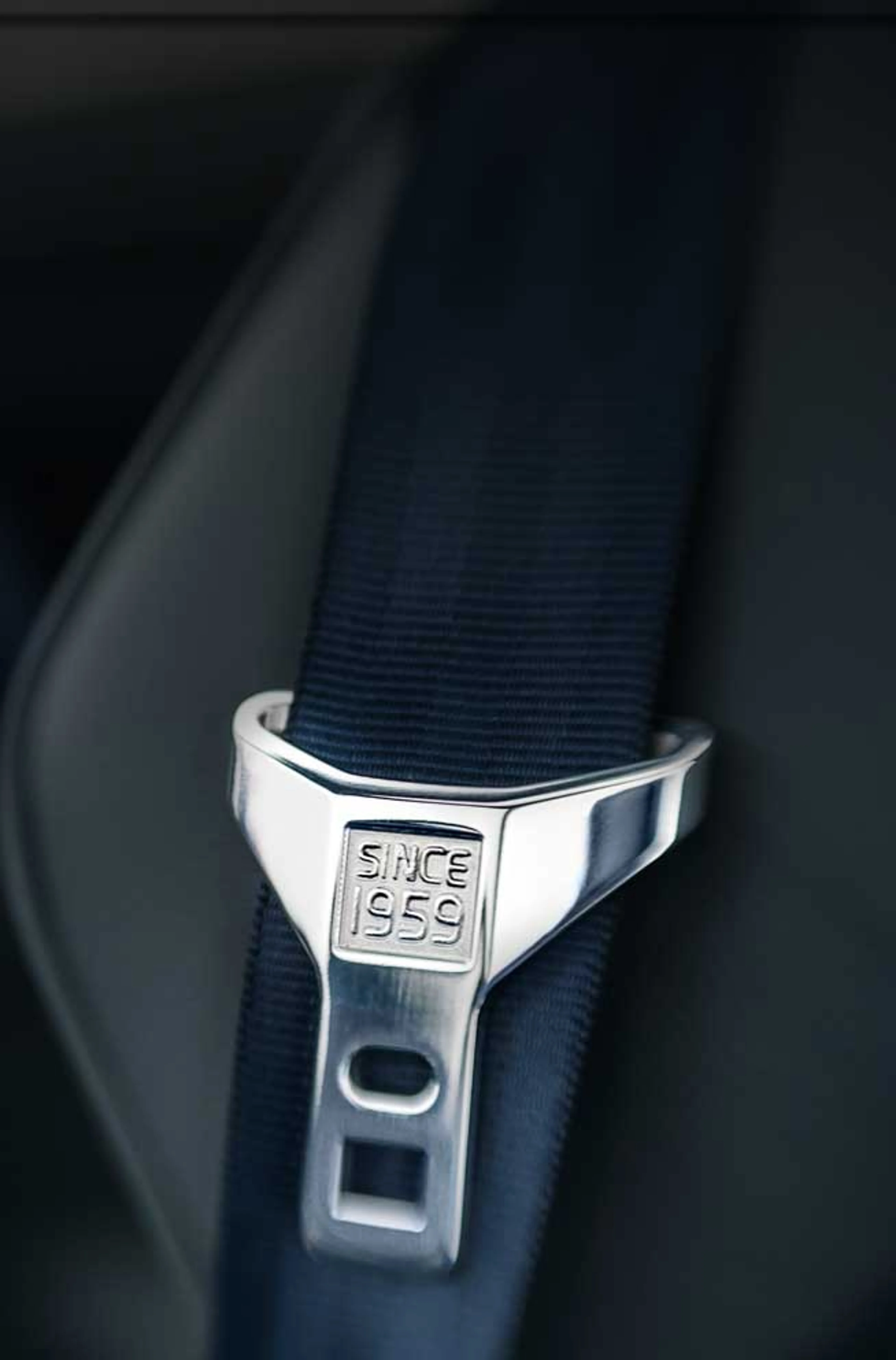 A safety belt in grey with the text "Since 1959" engraved on the buckle.