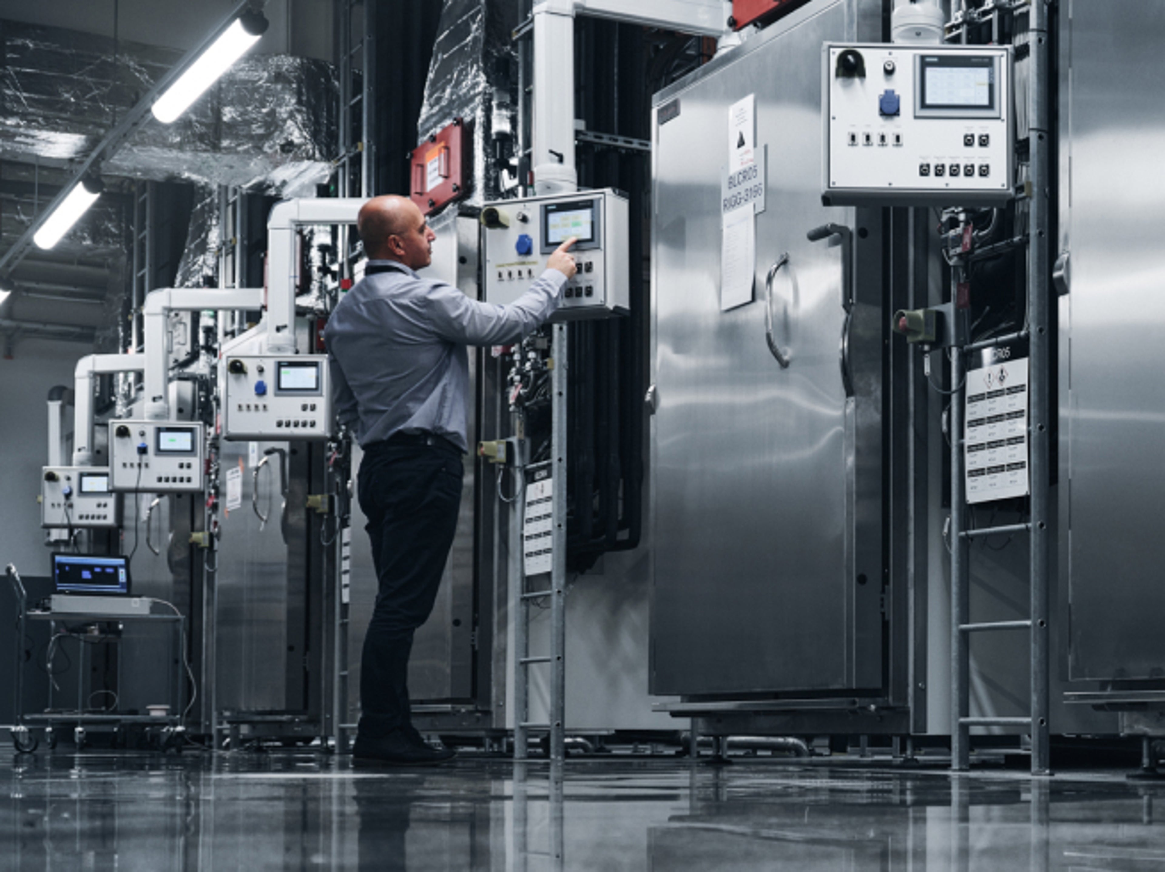 一位男士在工厂内操作系统。