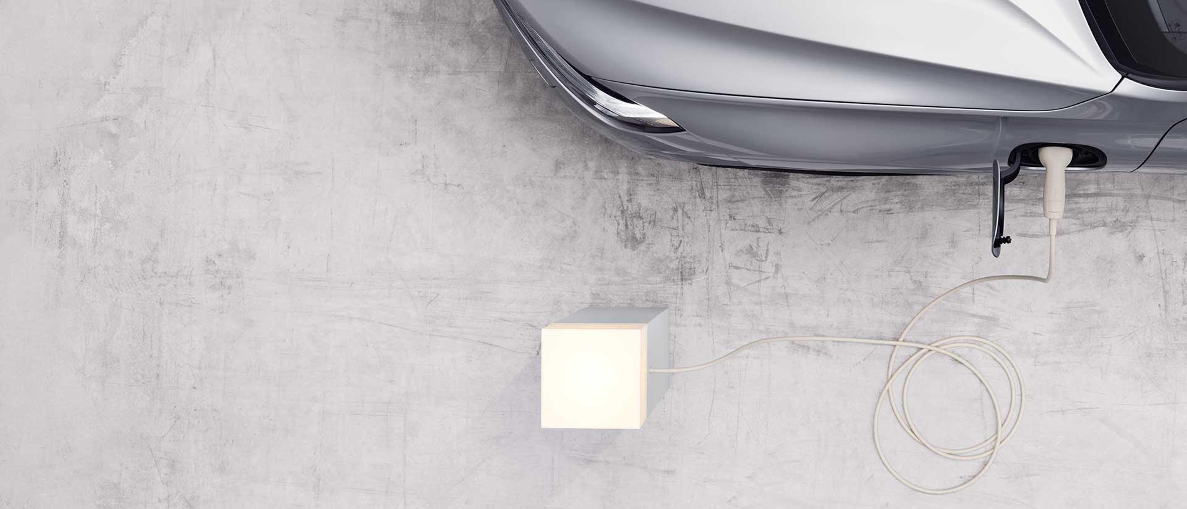 沃尔沃汽车在点亮的插座上充电的俯视图。