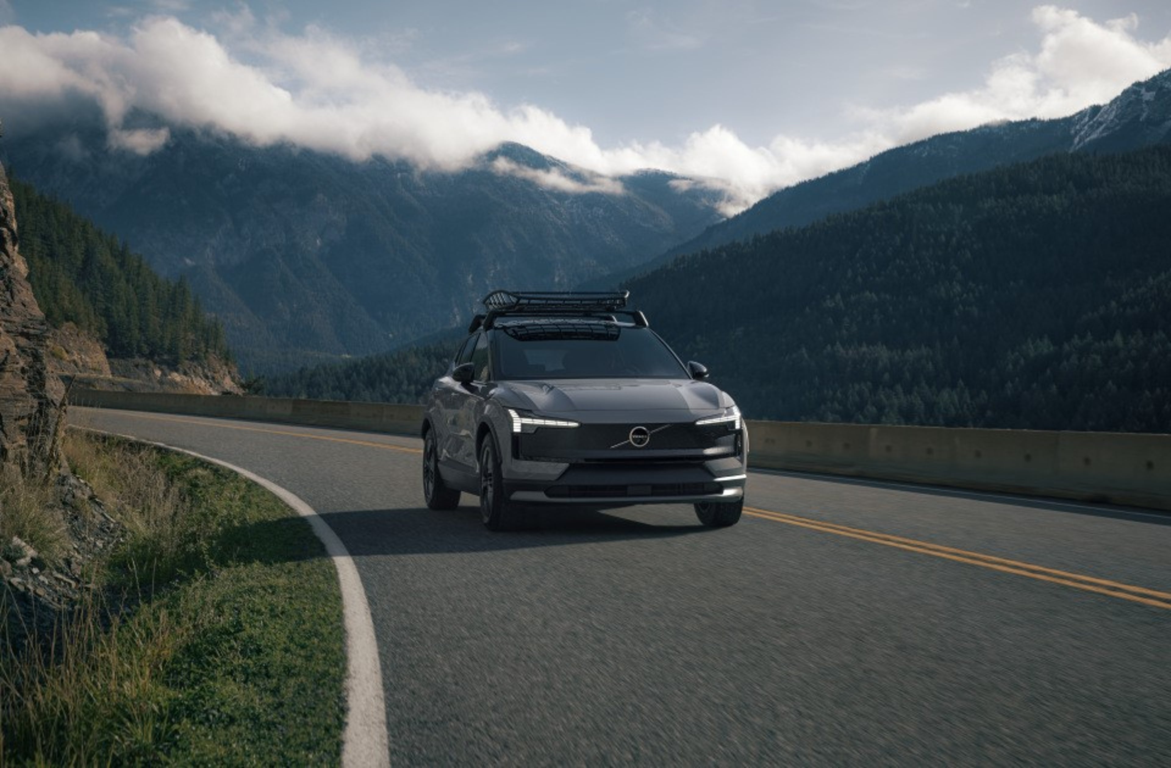 草地后面停着辆 EX30 Cross Country,特写镜头对准其全地形车轮和前保险杠。