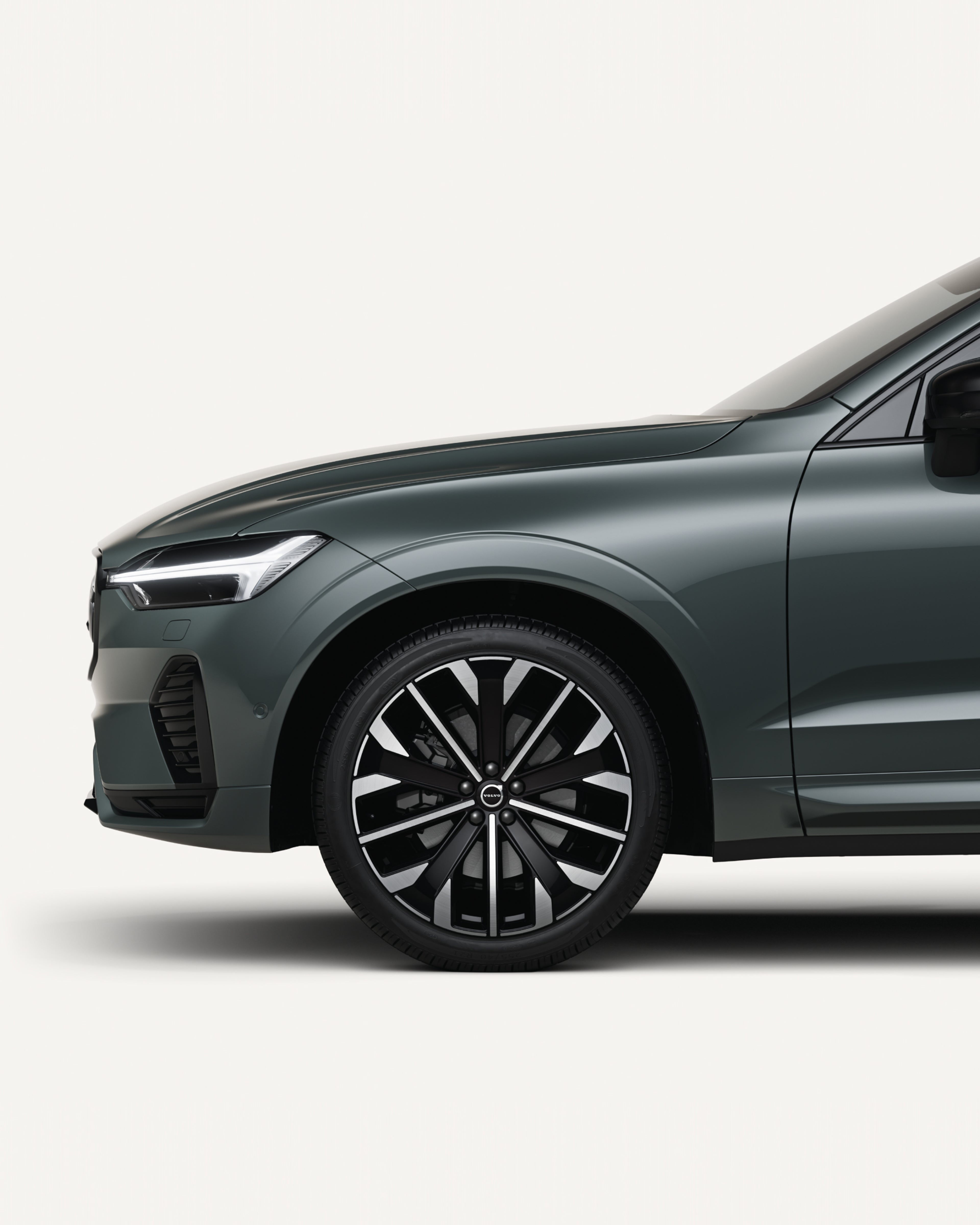 沃尔沃全新 XC60 轻度混合动力中型 SUV 停在白色工作室内的二分之一正视图。