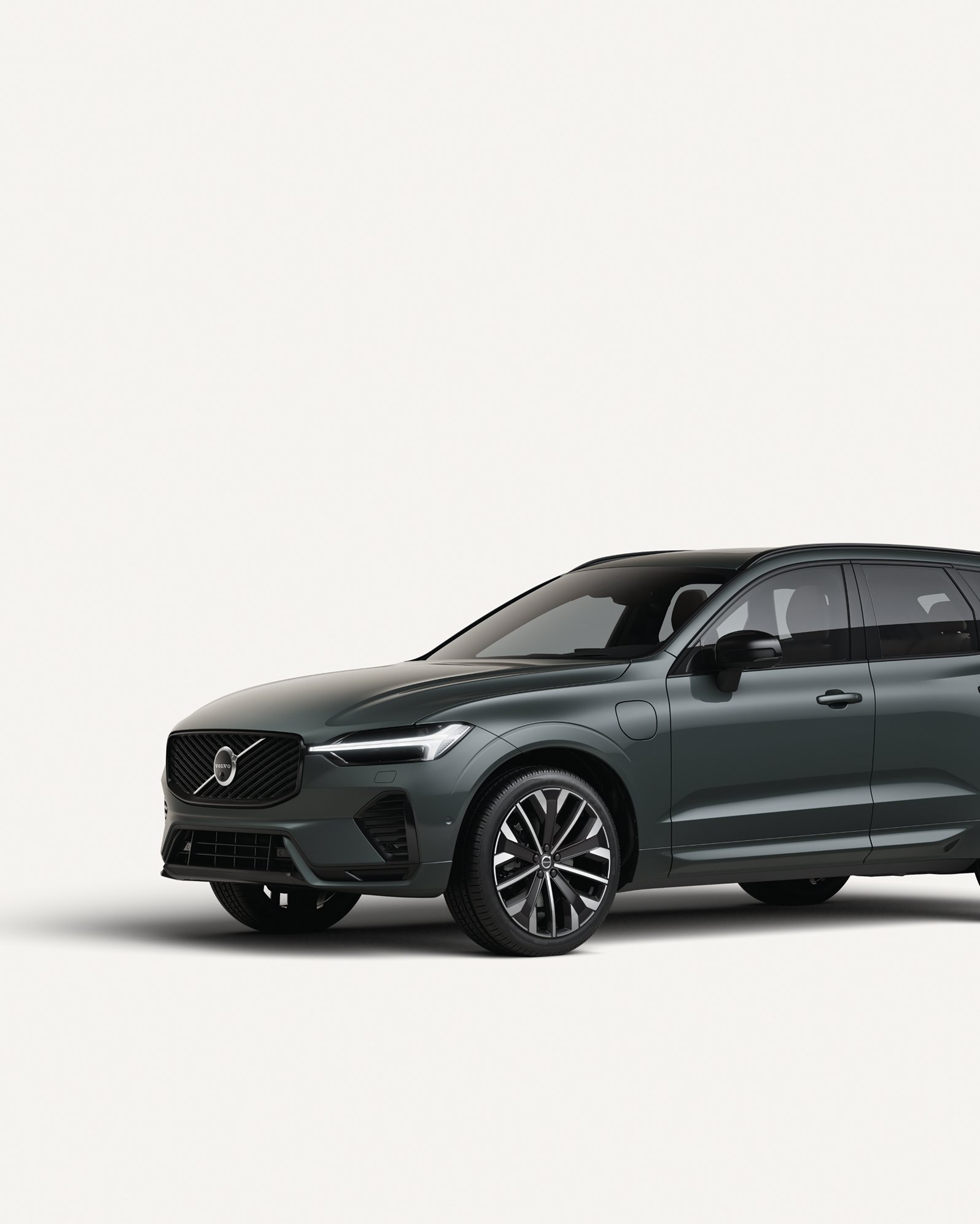 沃尔沃全新 XC60 插电式混合动力中型 SUV 停在白色工作室内的侧视图。