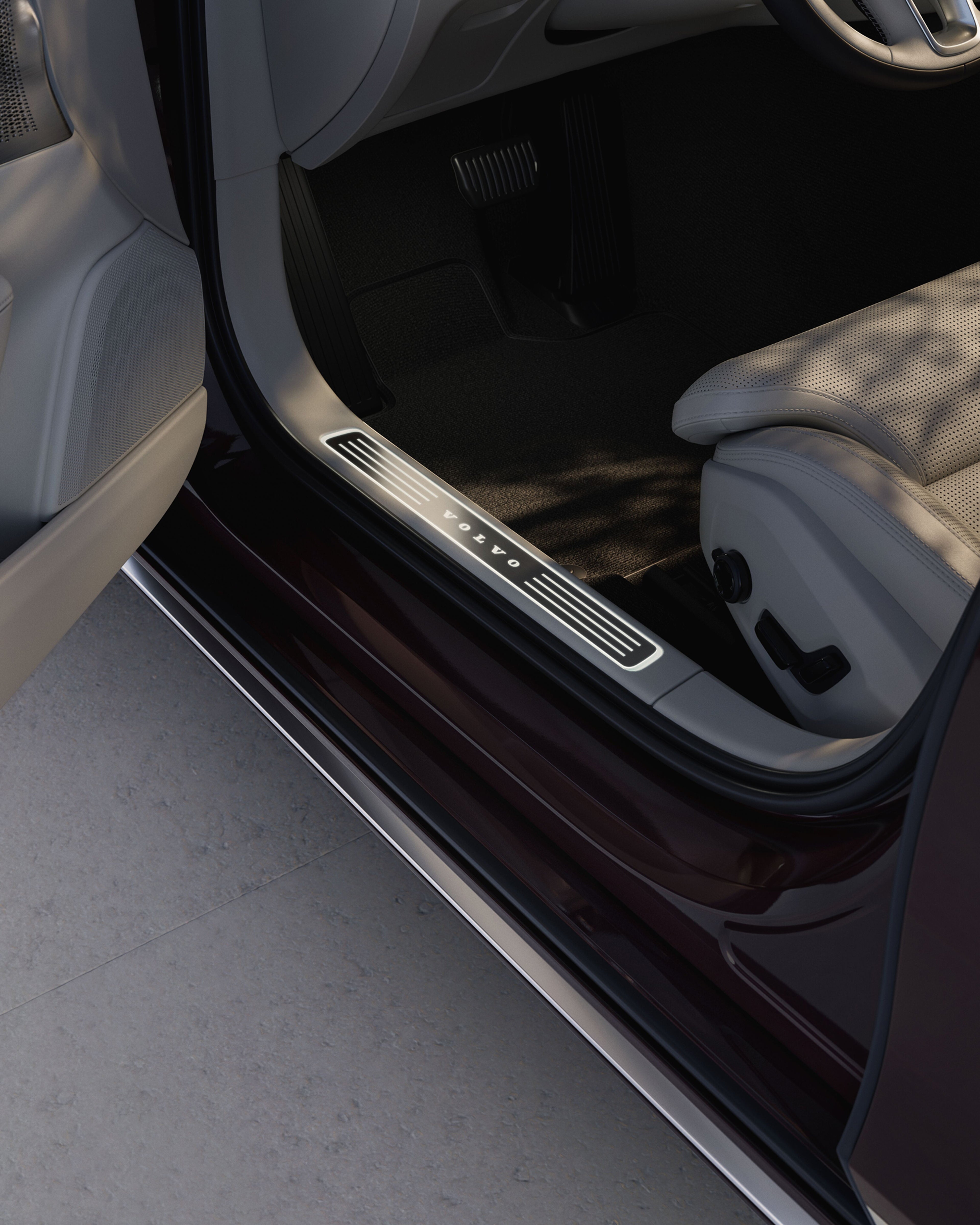 沃尔沃 S90 脚踏板上发光的沃尔沃汽车标识特写。