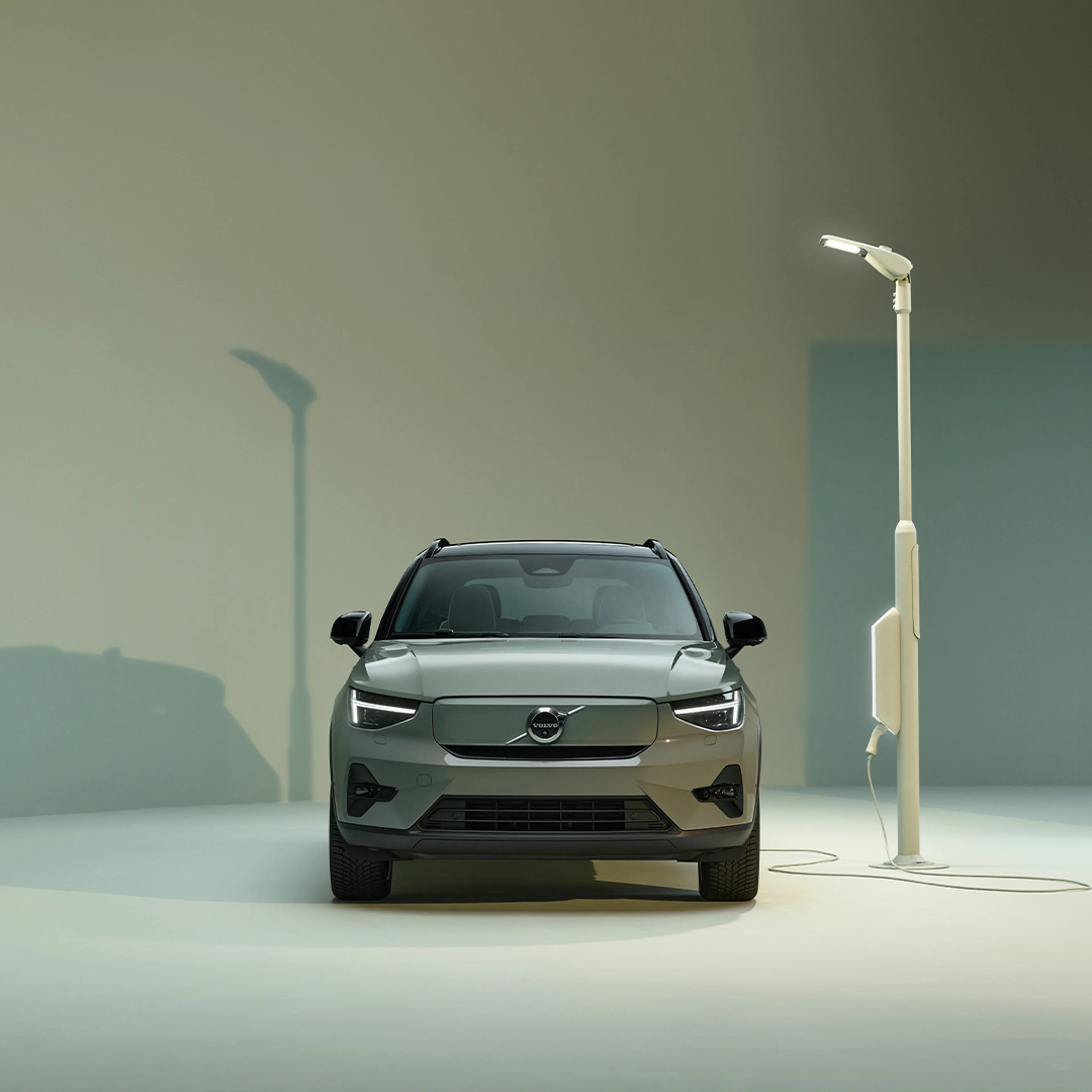 沃尔沃 XC40 RECHARGE 纯电动车型正面外观设计、充电口和充电站。