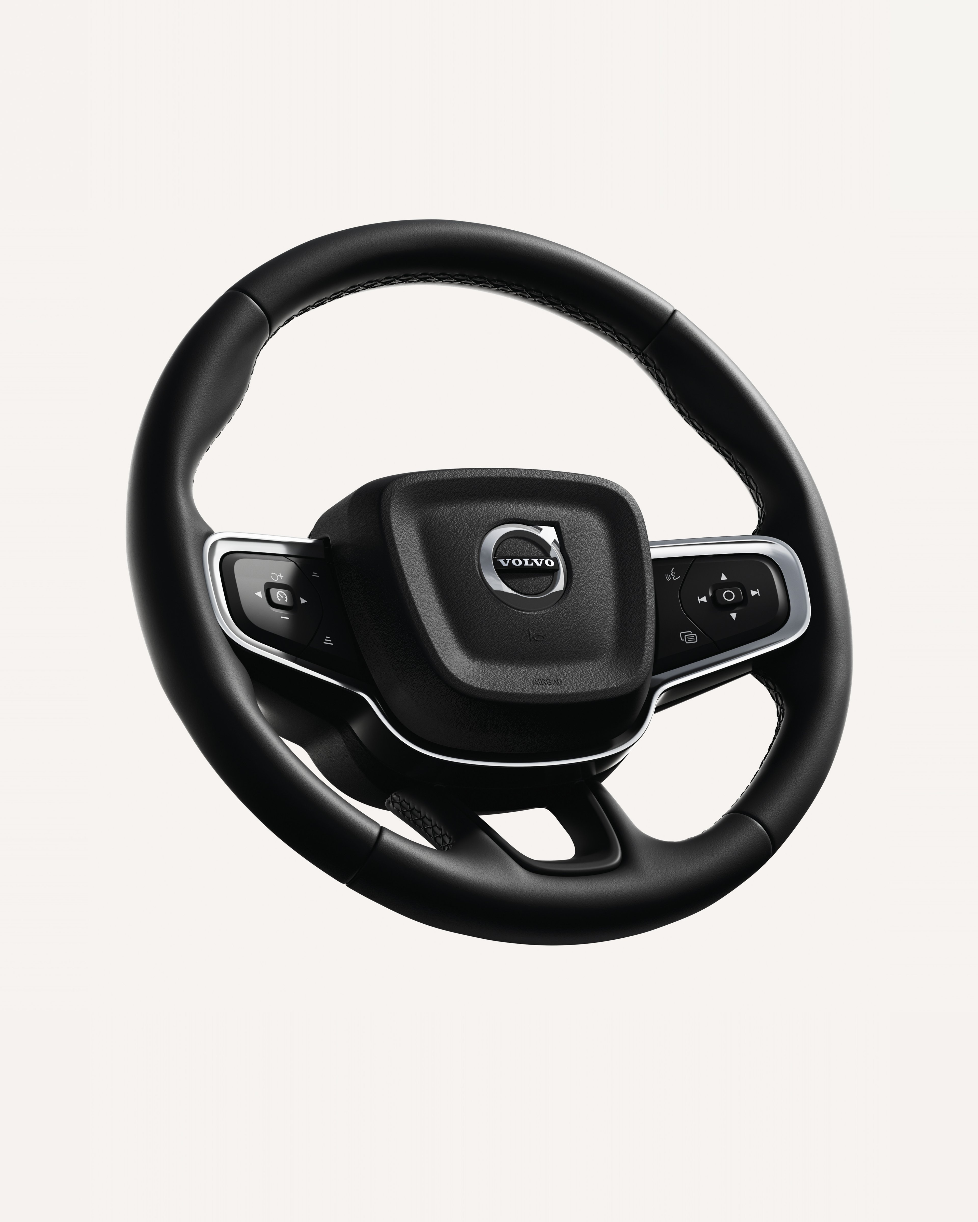 白色摄影棚内沃尔沃 XC40 方向盘特写,重点展示集成按键。