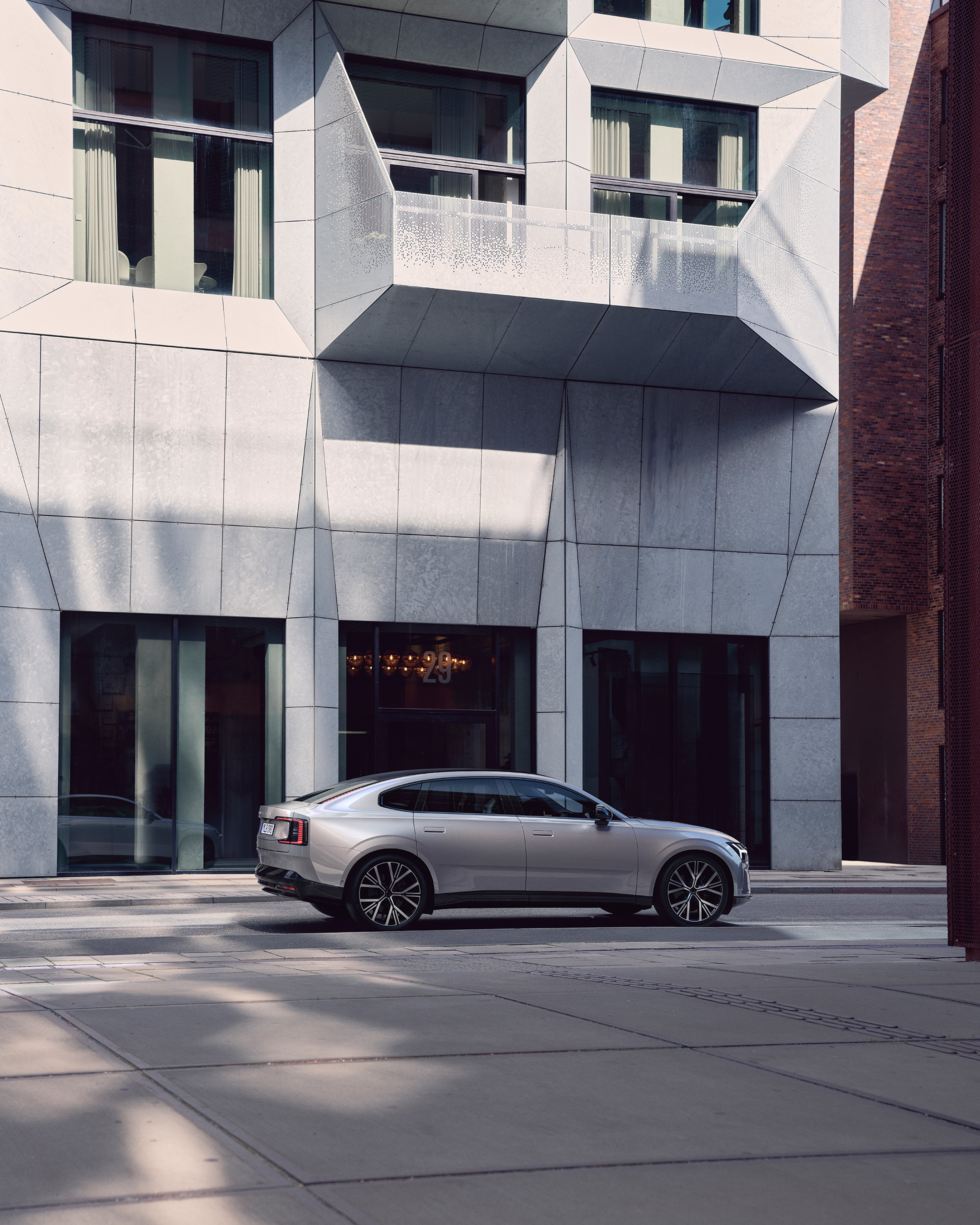 纯电沃尔沃 ES90 侧面视角,背景为现代建筑。