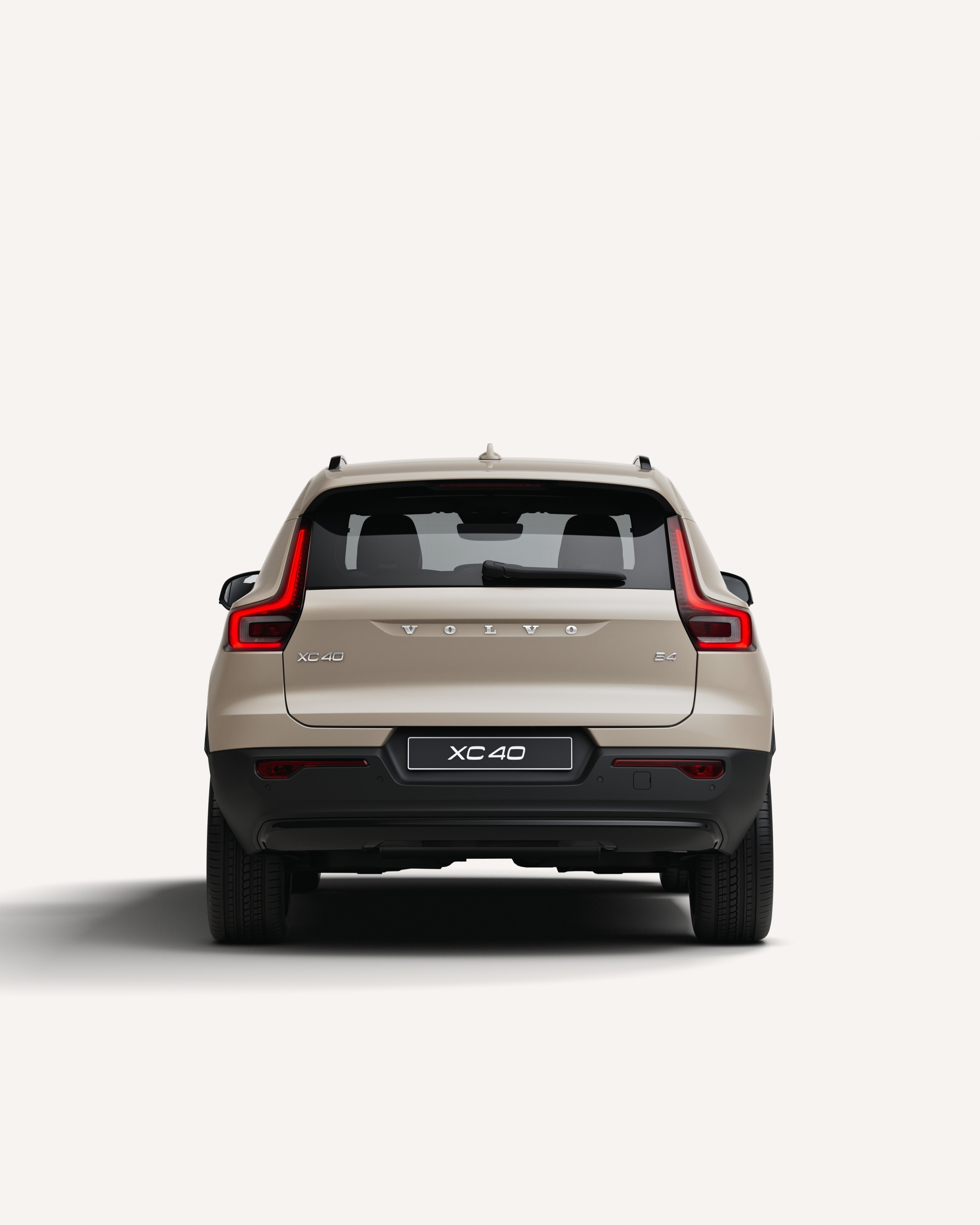 白色摄影棚内沃尔沃 XC40 轻度混合动力 SUV 后视图。