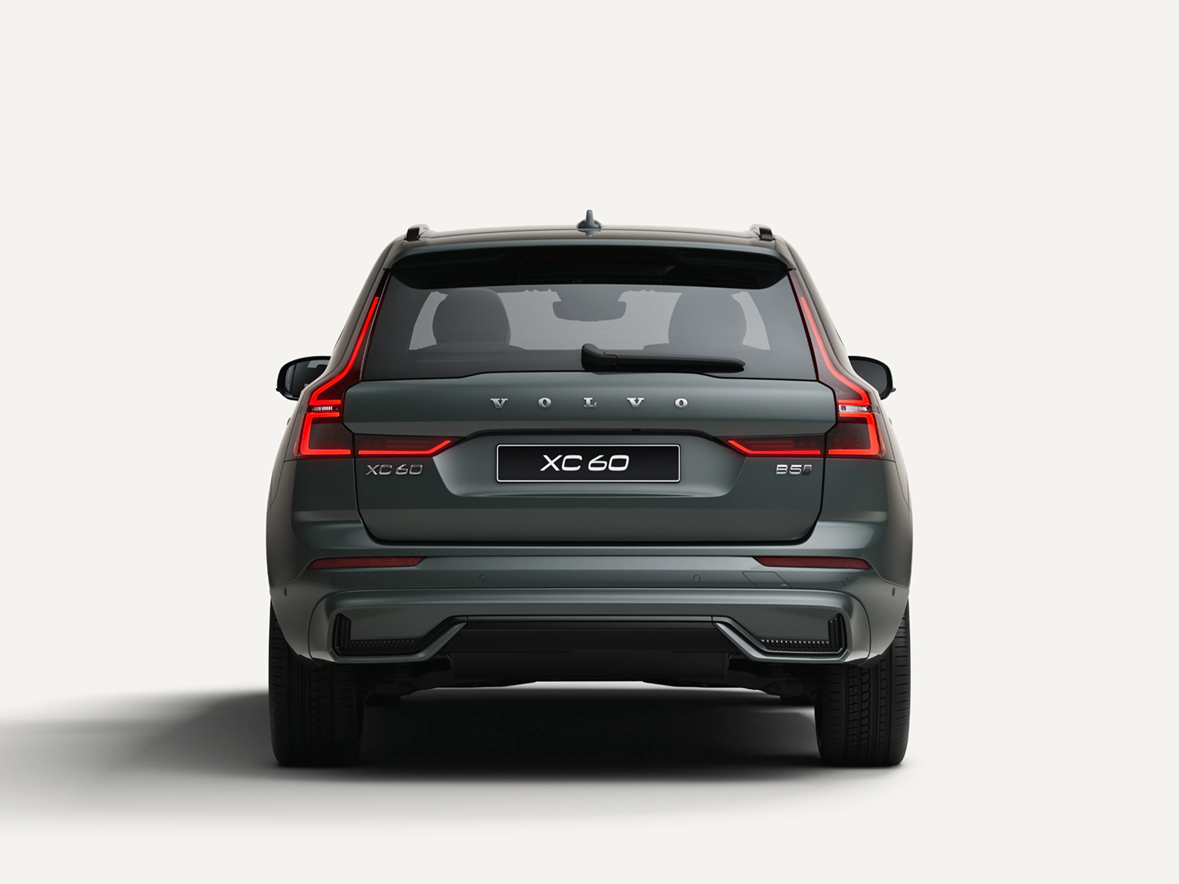 沃尔沃全新 XC60 轻度混合动力中型 SUV 停在白色工作室内的后视图。