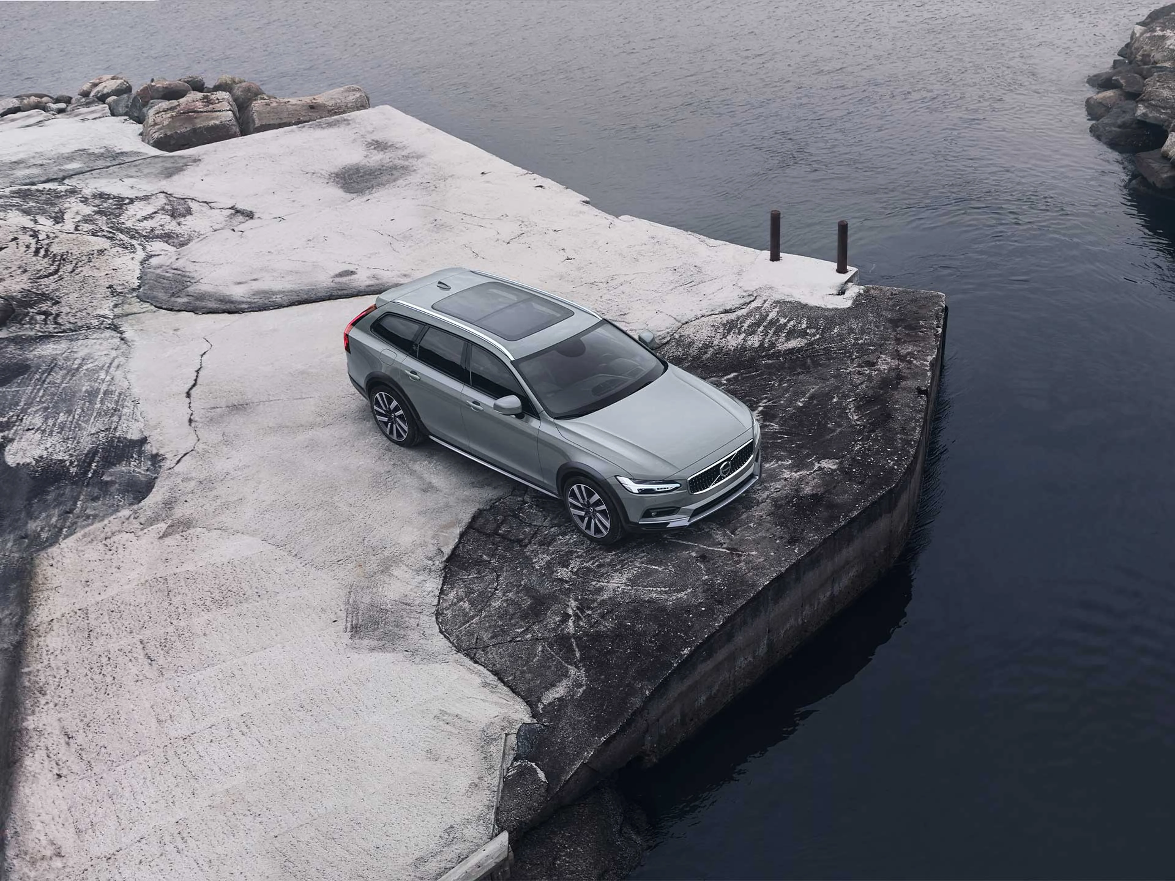 一辆沃尔沃 V90 Cross Country 轻度混合动力车行驶在山路上。
