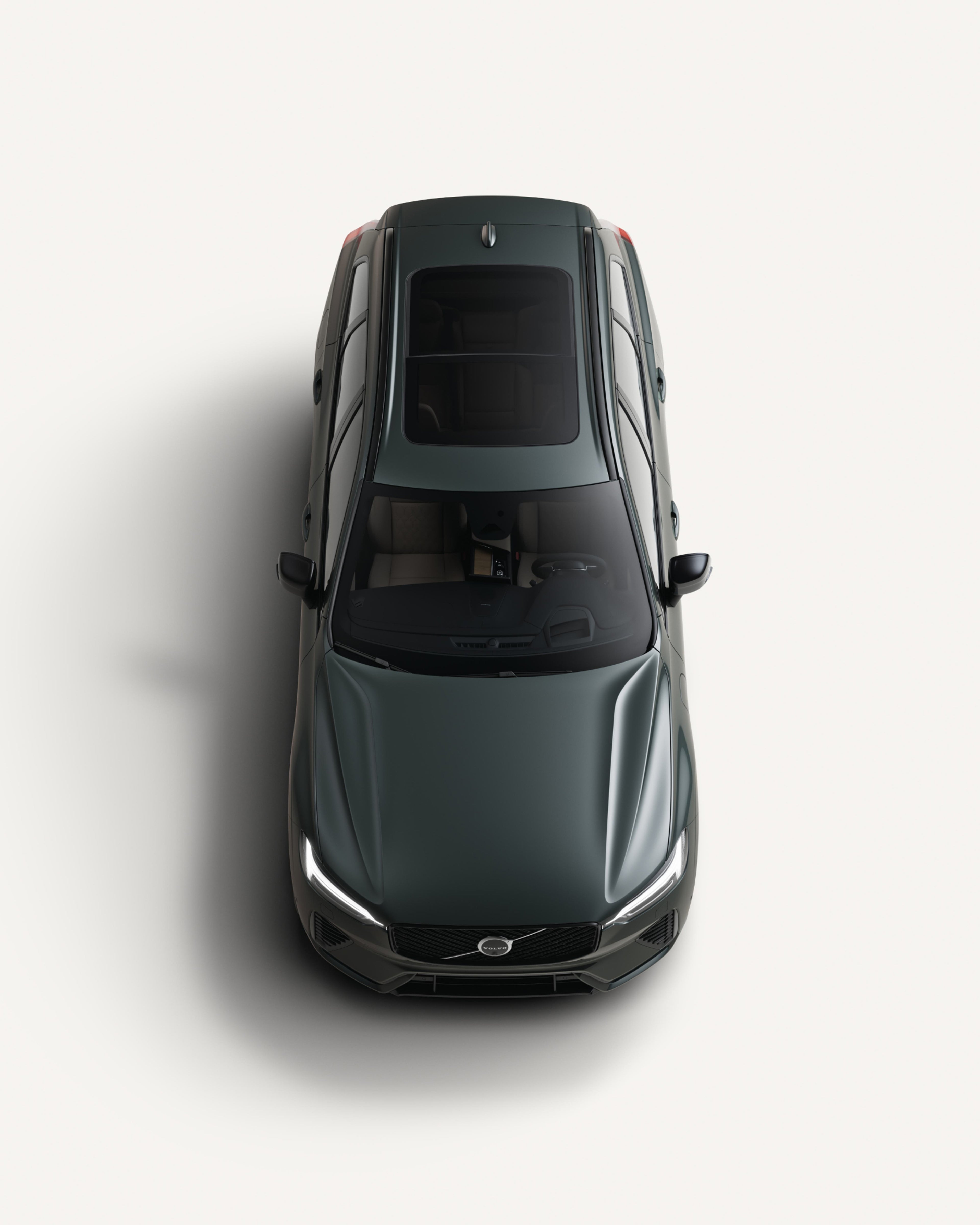 沃尔沃全新 XC60 插电式混合动力中型 SUV 停在白色工作室内的鸟瞰图。