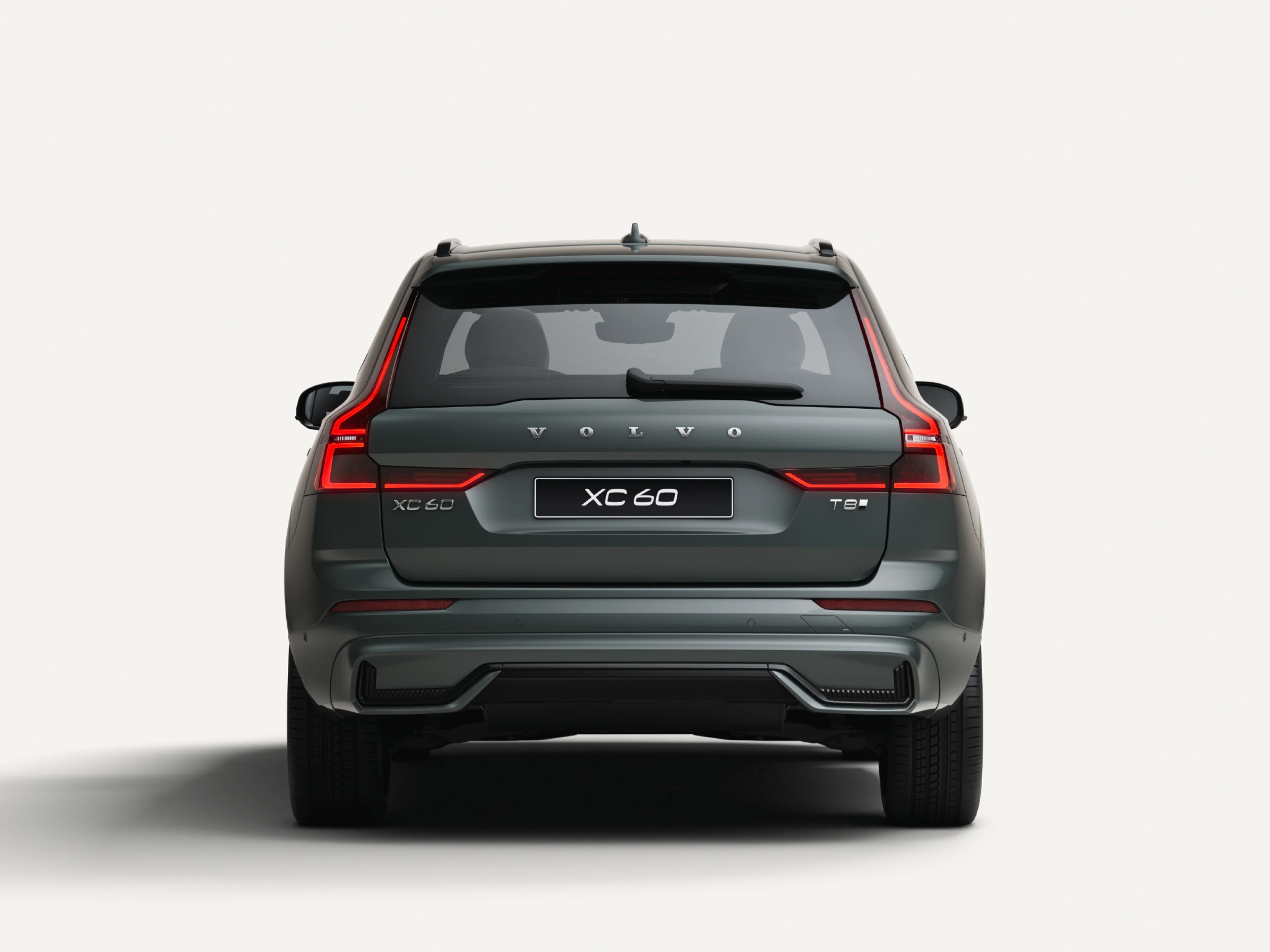 沃尔沃全新 XC60 插电式混合动力中型 SUV 停在白色工作室内的后视图。