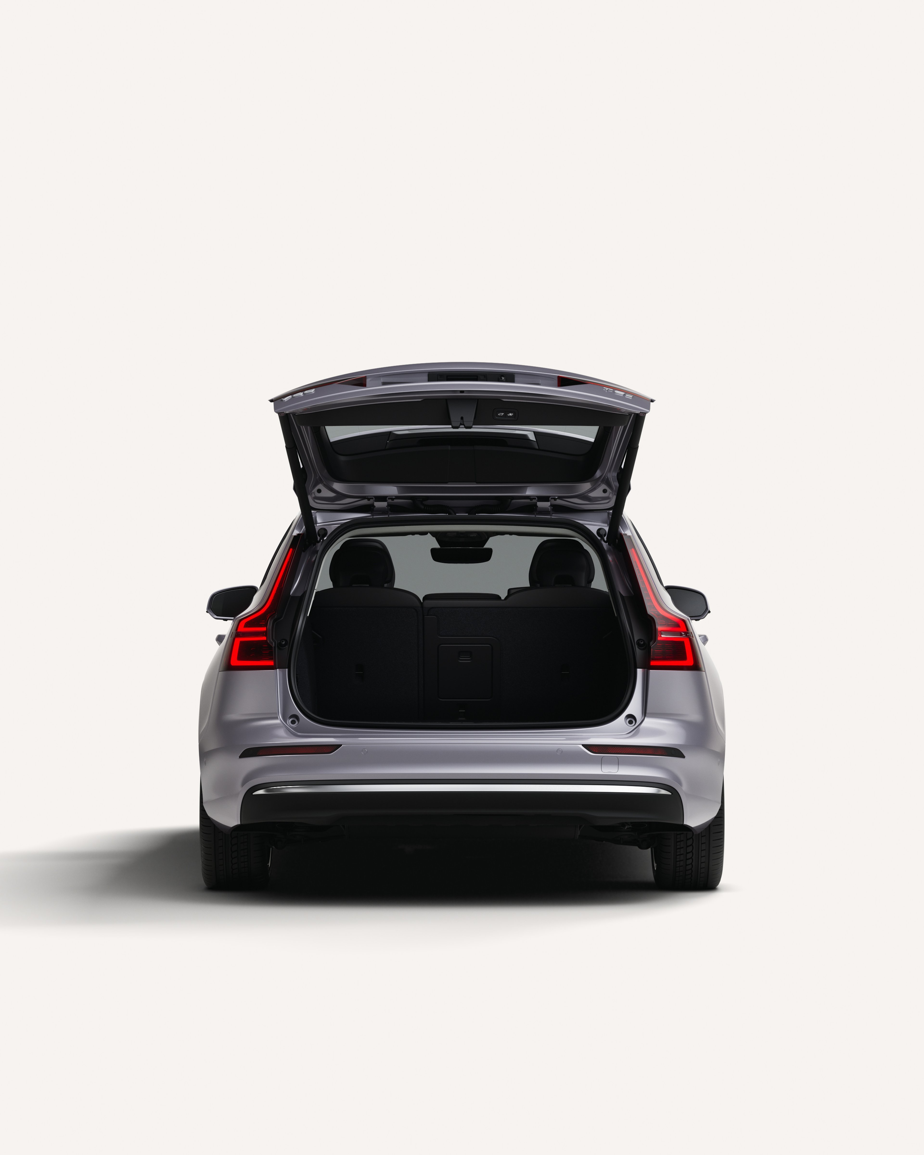 白色摄影棚内沃尔沃 V60 后备厢敞开着的后视图。