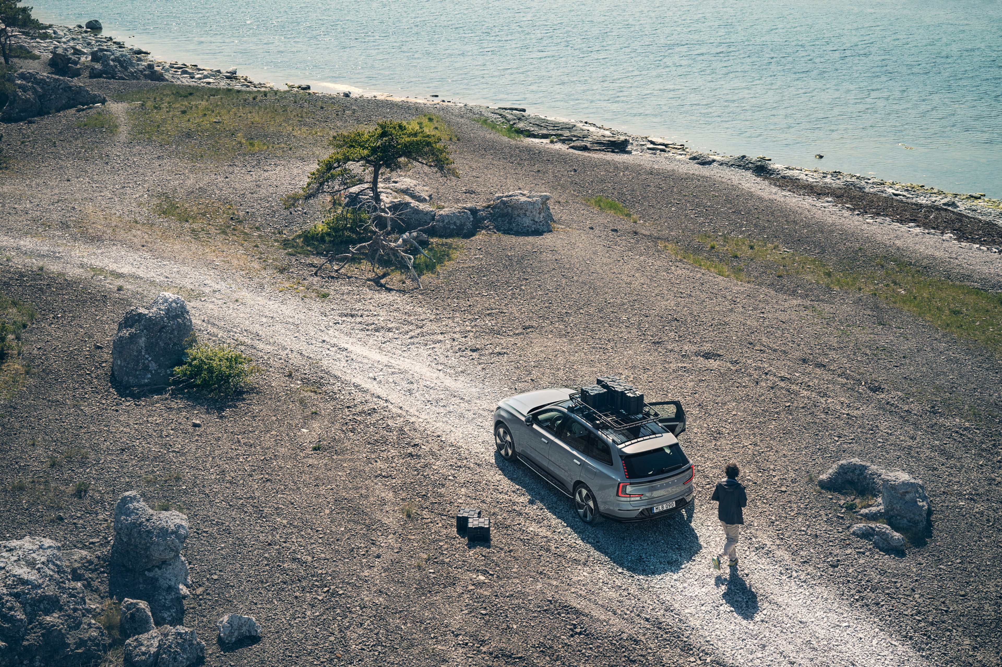 一辆沃尔沃停在一条碎石路上,货物稳稳地装载在车顶上。