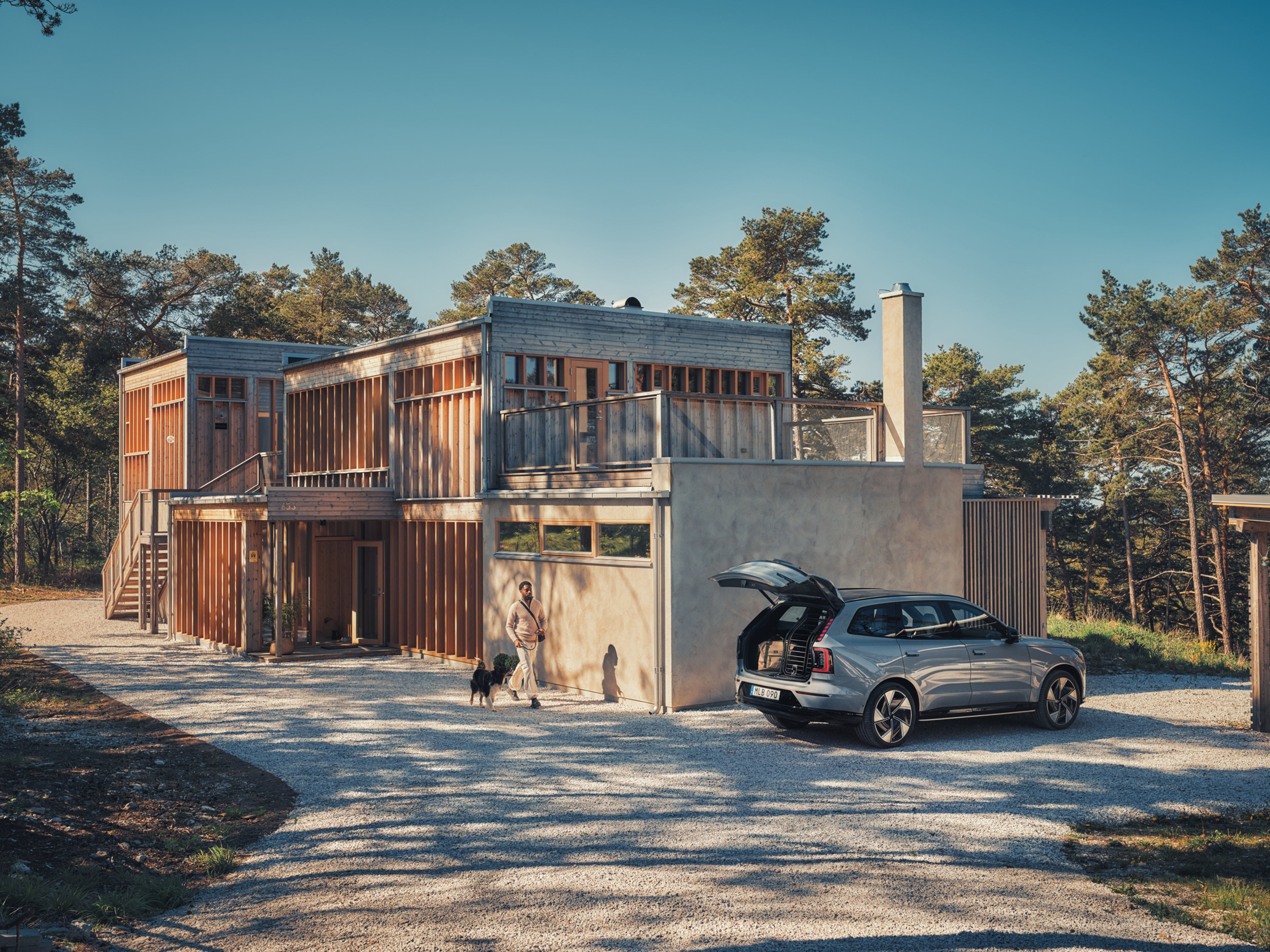 一名沃尔沃司机正准备将他的狗安全地放入汽车后备箱内的狗门中。