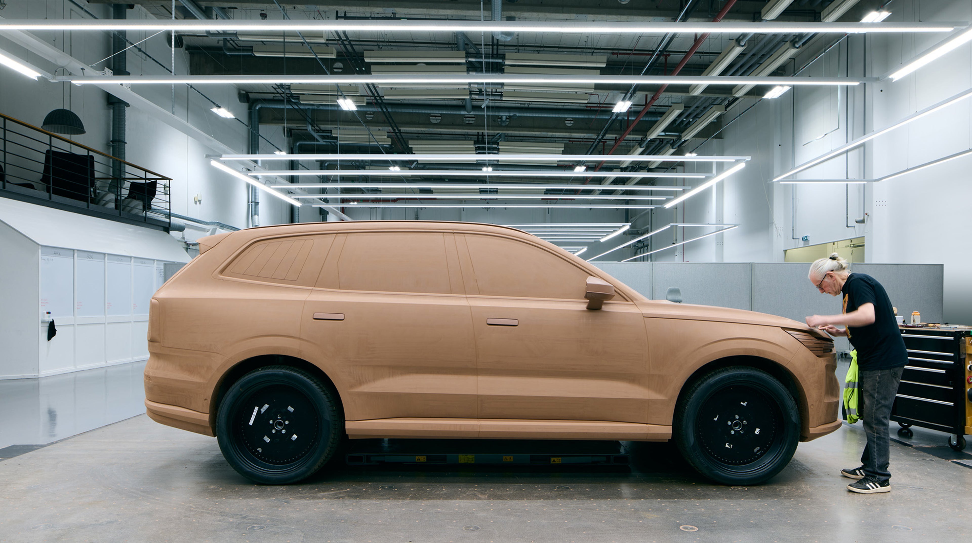 一名油泥模型师在沃尔沃汽车设计工作室内精心手工雕刻汽车原型。