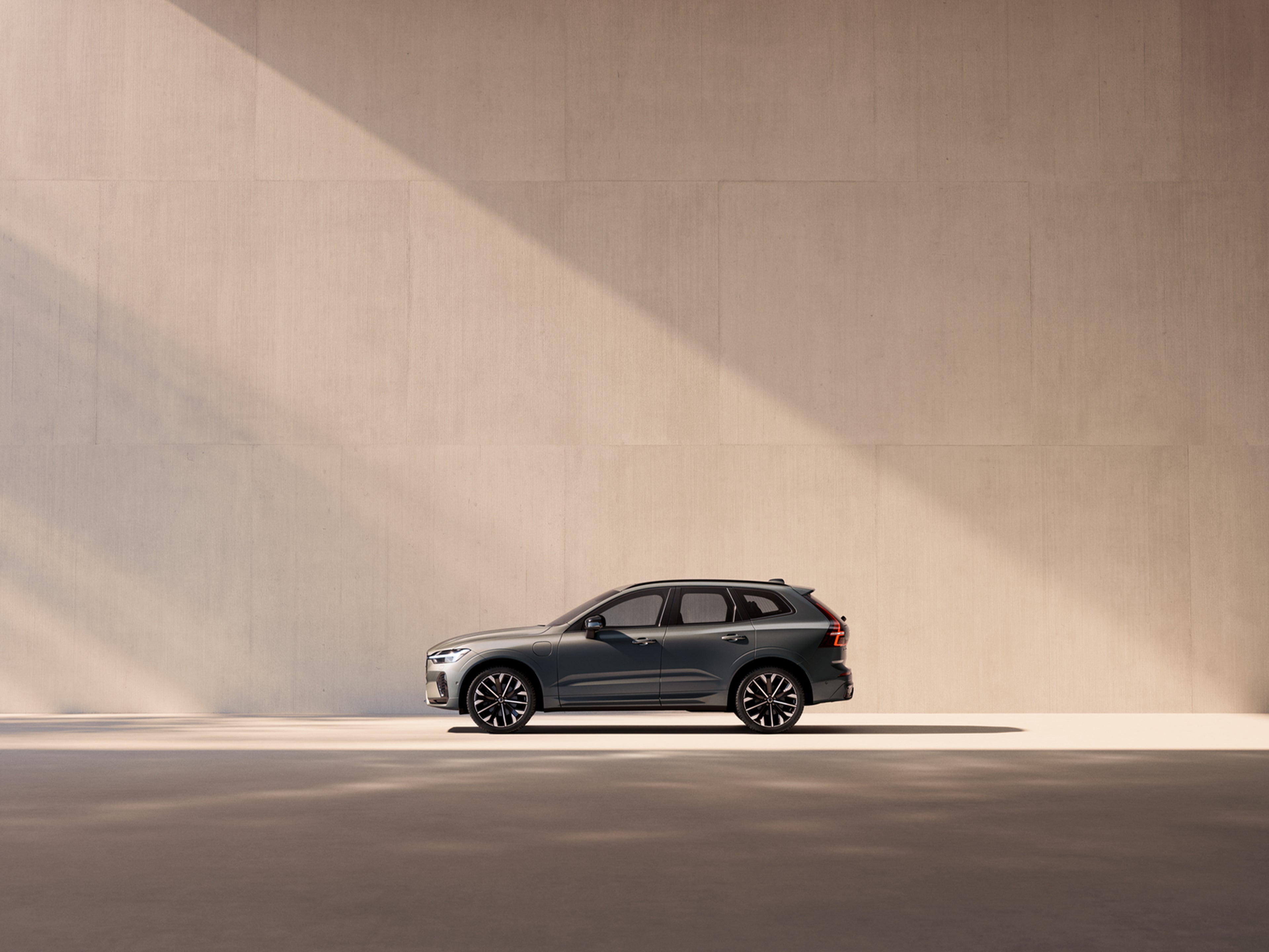 粉紫色五彩阳光下,沃尔沃 XC60 停在空置工业场所内。