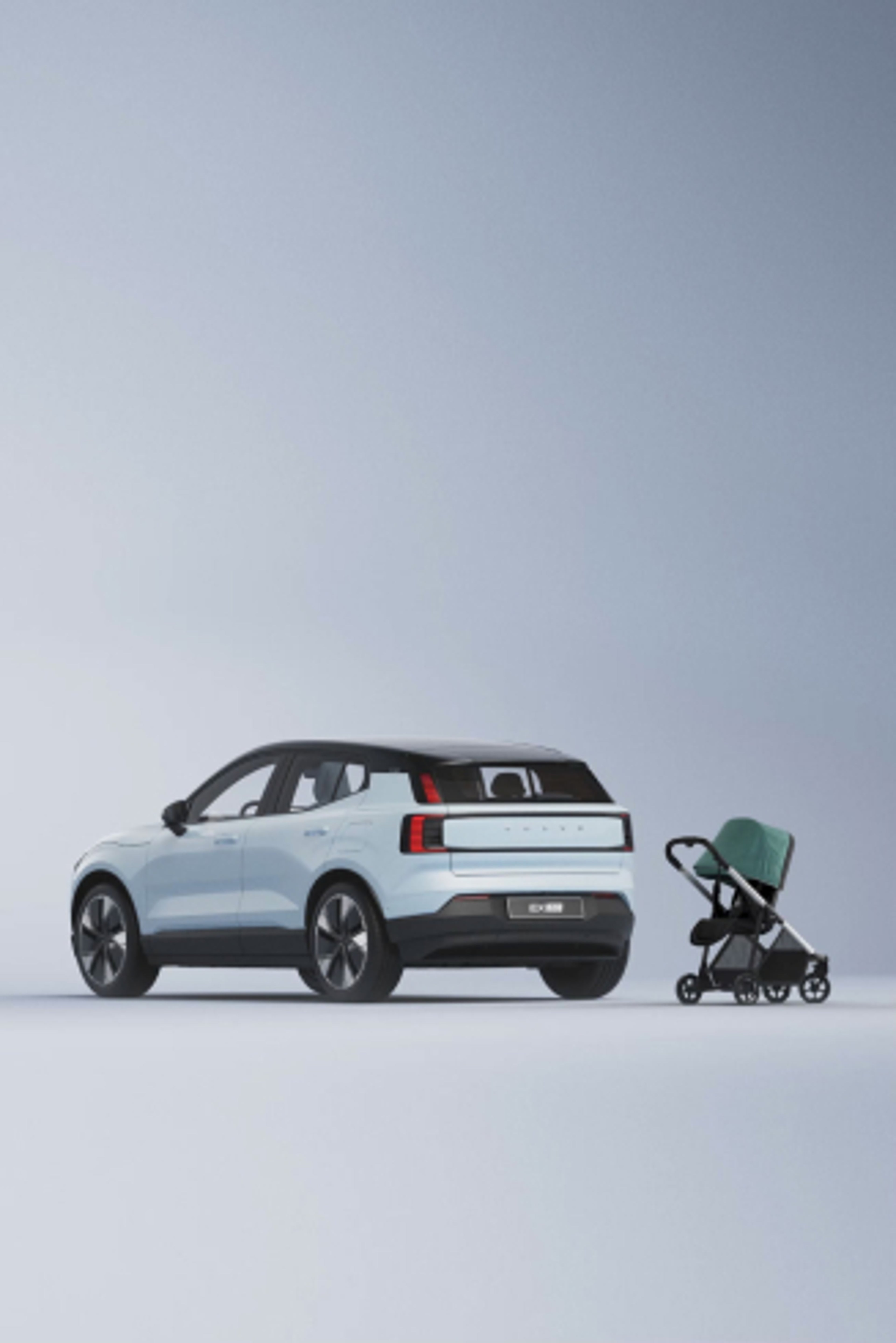 沃尔沃 EX30 后四分之三视图,旁边有一辆折叠式婴儿车。