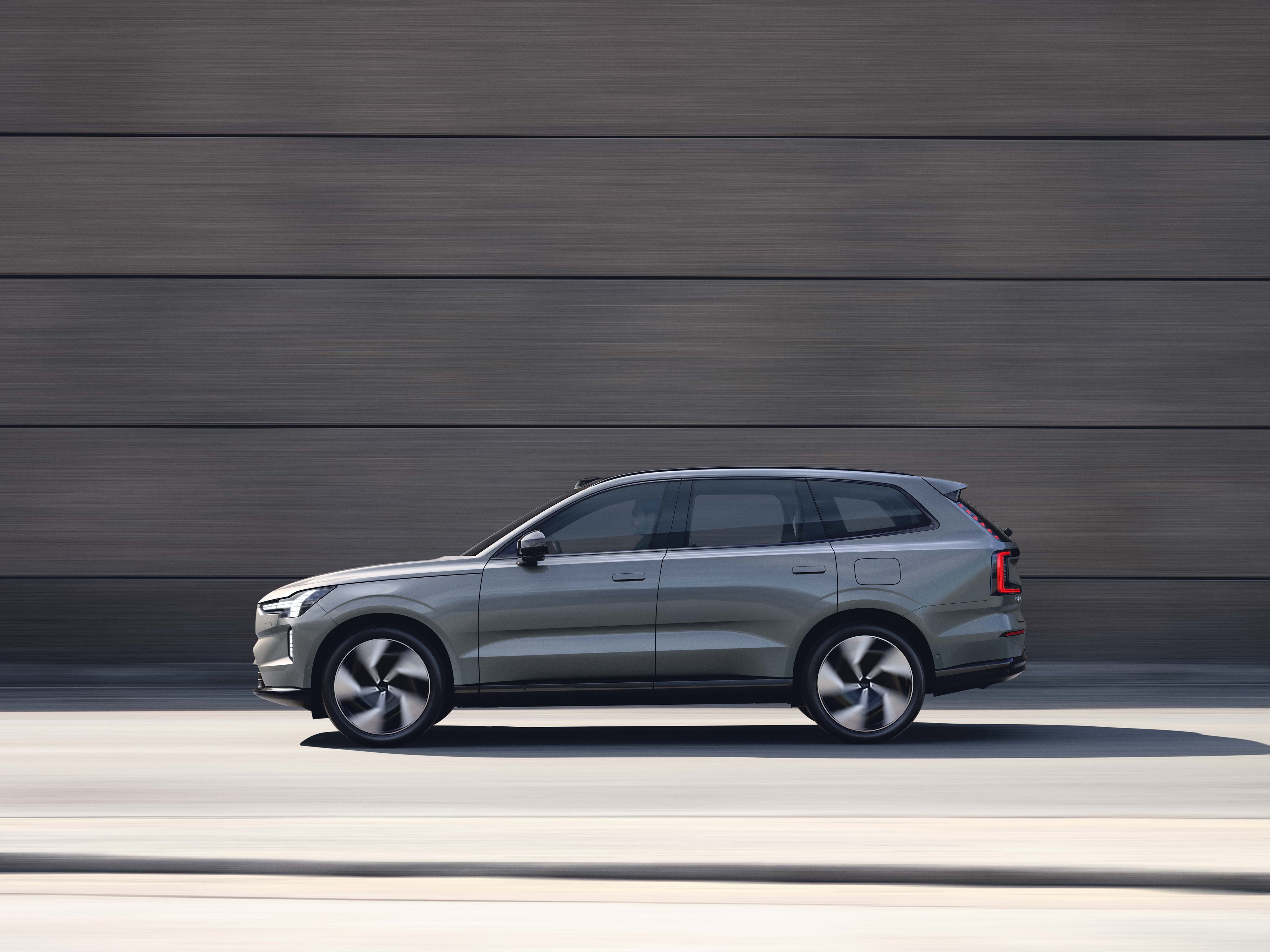 沃尔沃 EX90 沿混凝土墙移动的外观视图。