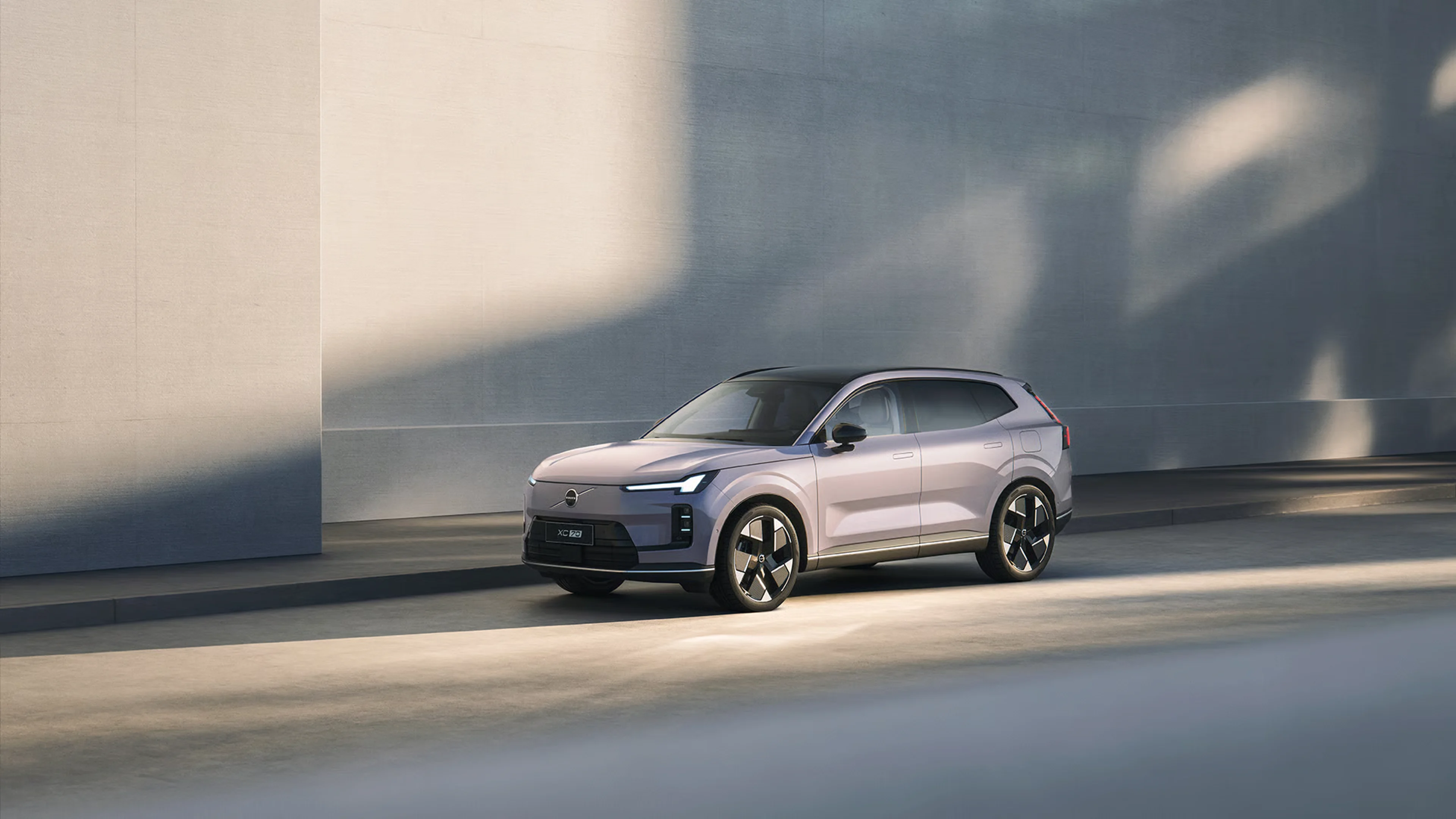 沃尔沃 XC70 超级混动停靠于现代简约墙边,展示智能切换技术,油电动力无缝转换。