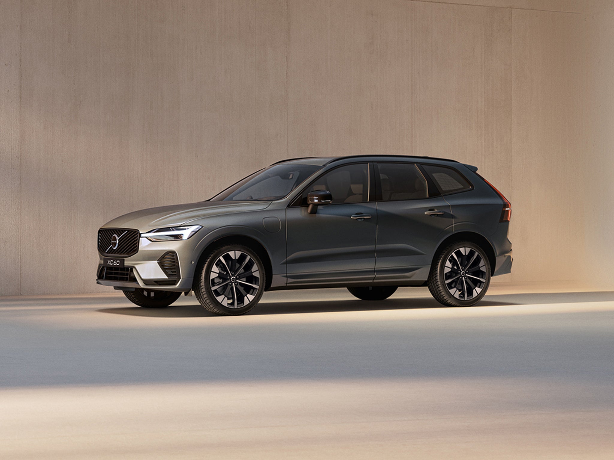 沃尔沃 XC60 插电式混合动力汽车前半部分侧面车身在空旷室内充电中侧面轮廓。