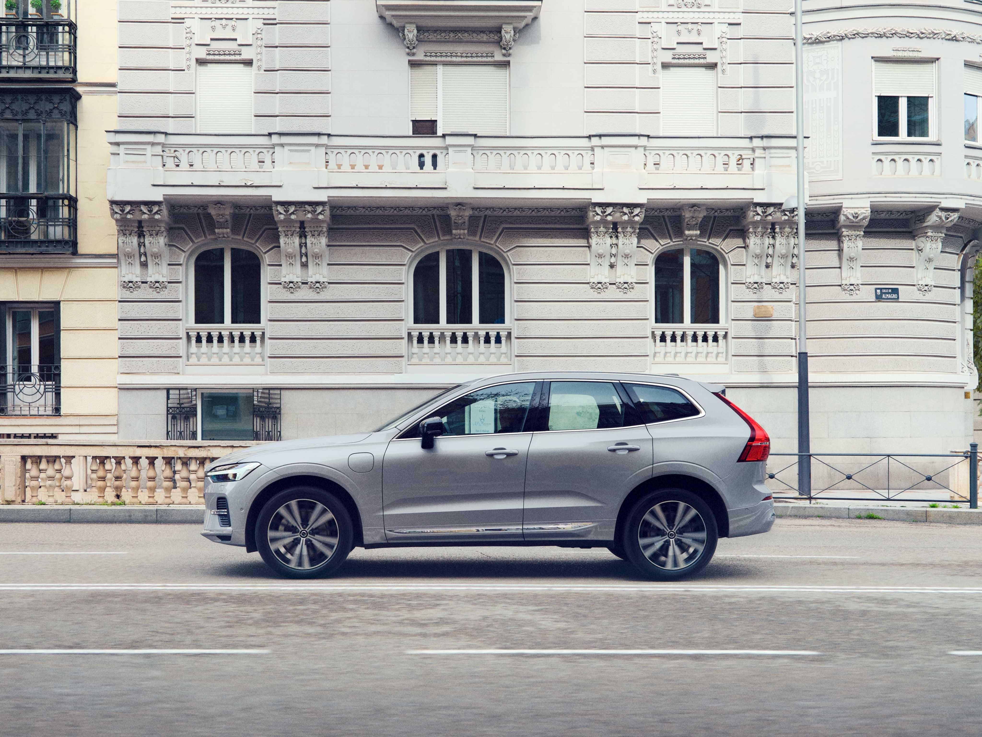 晨光银沃尔沃 XC60 行驶在欧洲街道上的广角视图。