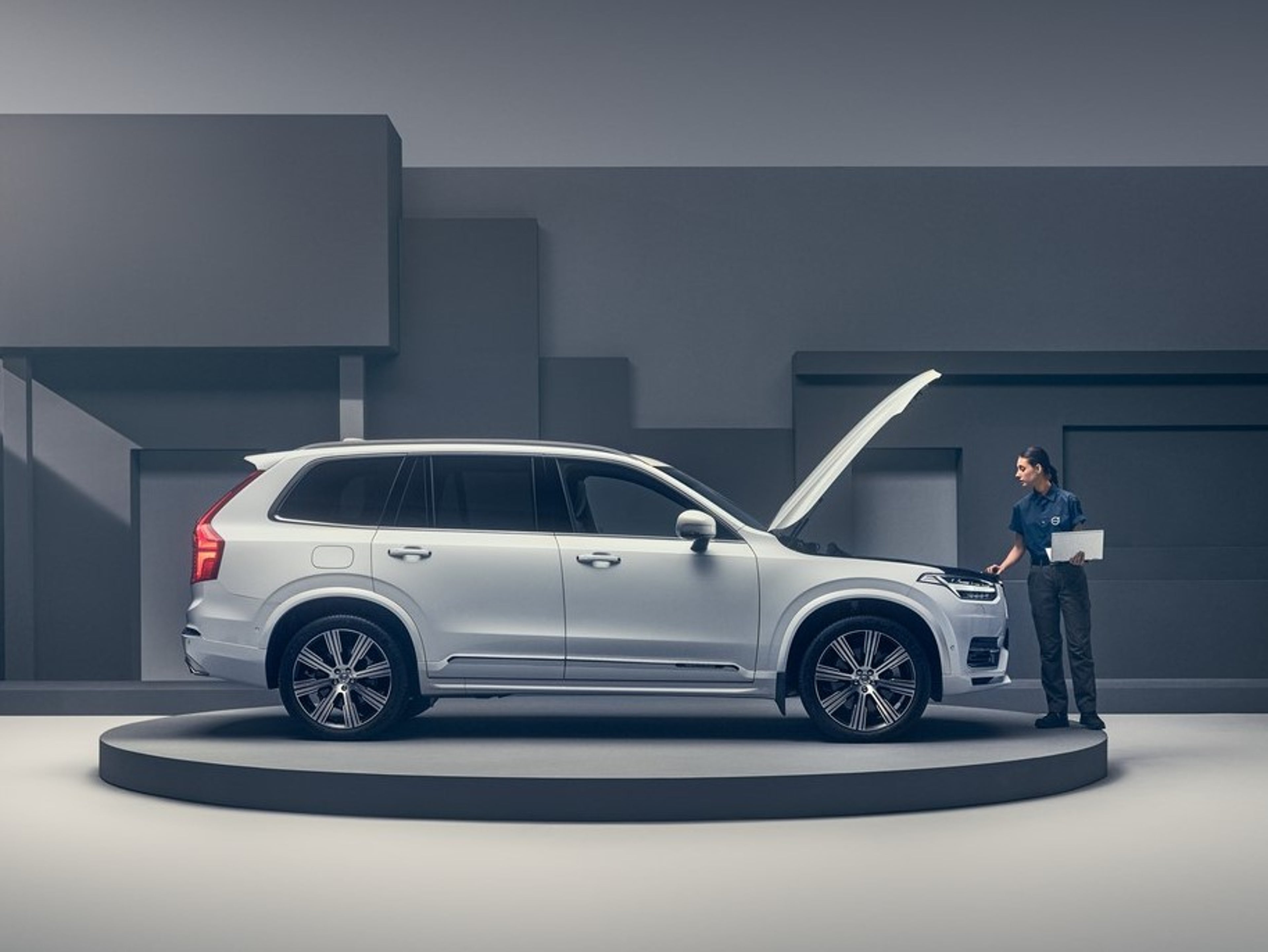 女技术人员正在检查引擎盖打开的白色沃尔沃汽车。