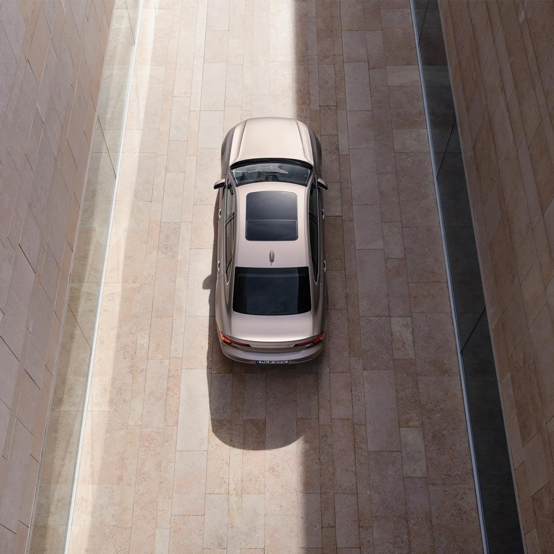 Volvo S90 插电式混合动力轿车穿梭楼宇间尾部视图。