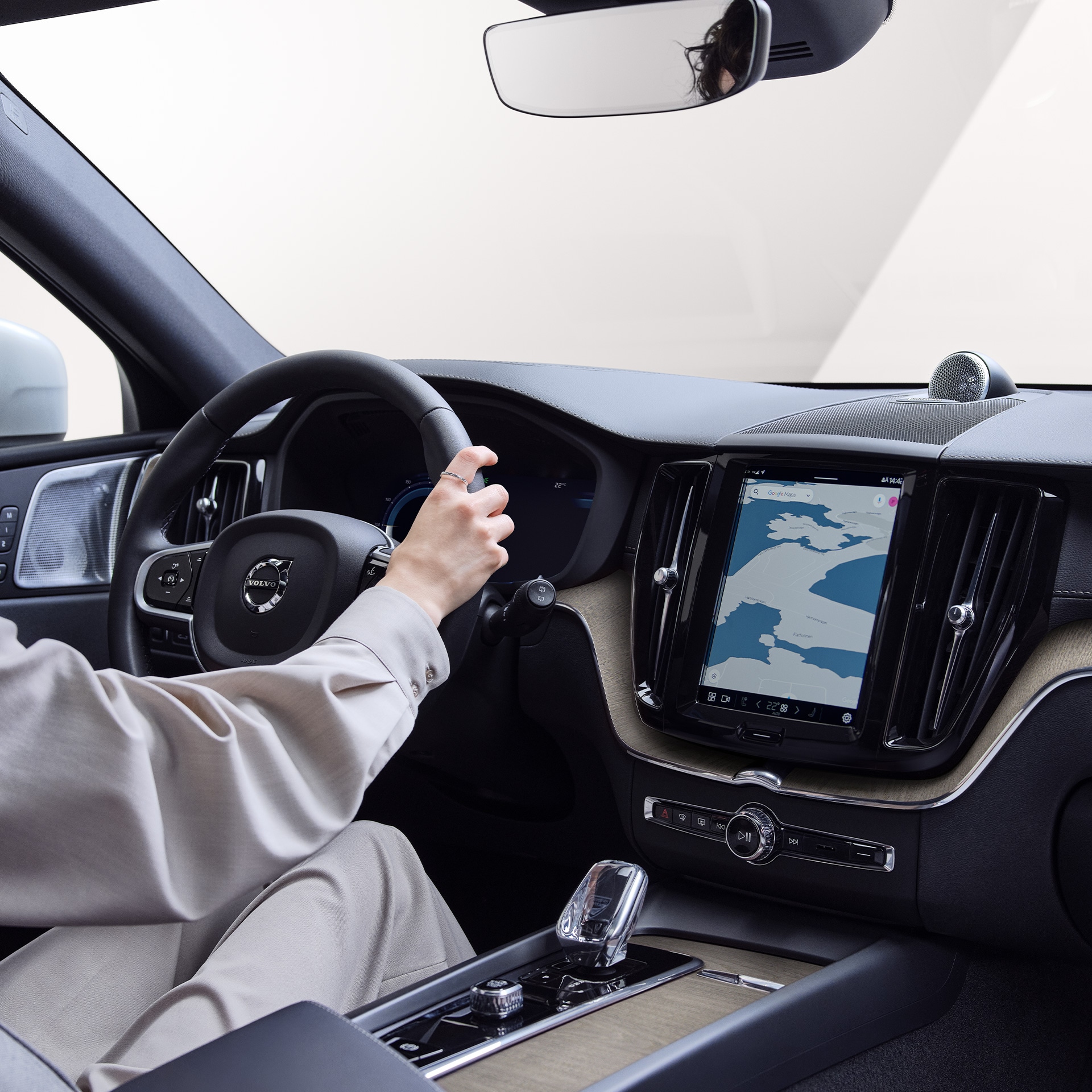 内部视角显示一名女士边看着中控台上的地图边驾驶着沃尔沃XC60 RECHARGE。