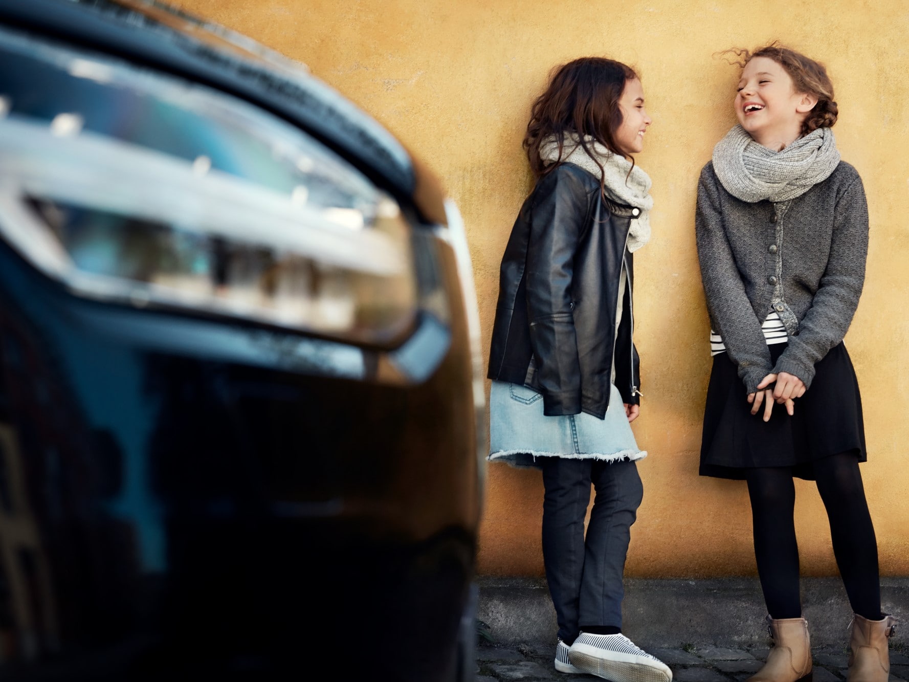 两名年轻女性在沃尔沃车旁。