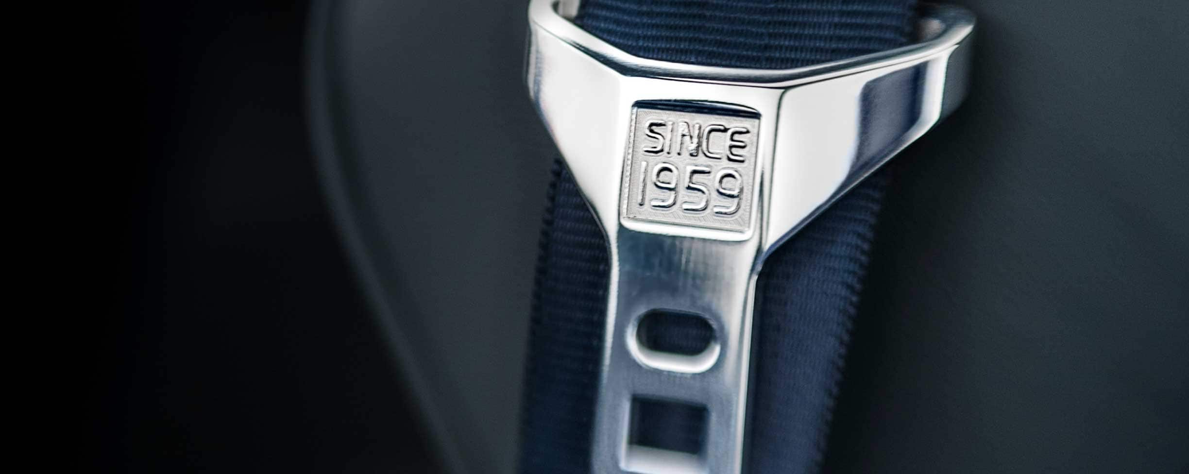 灰色安全带，带扣上刻有“ Since 1959”（源自1959年）字样。